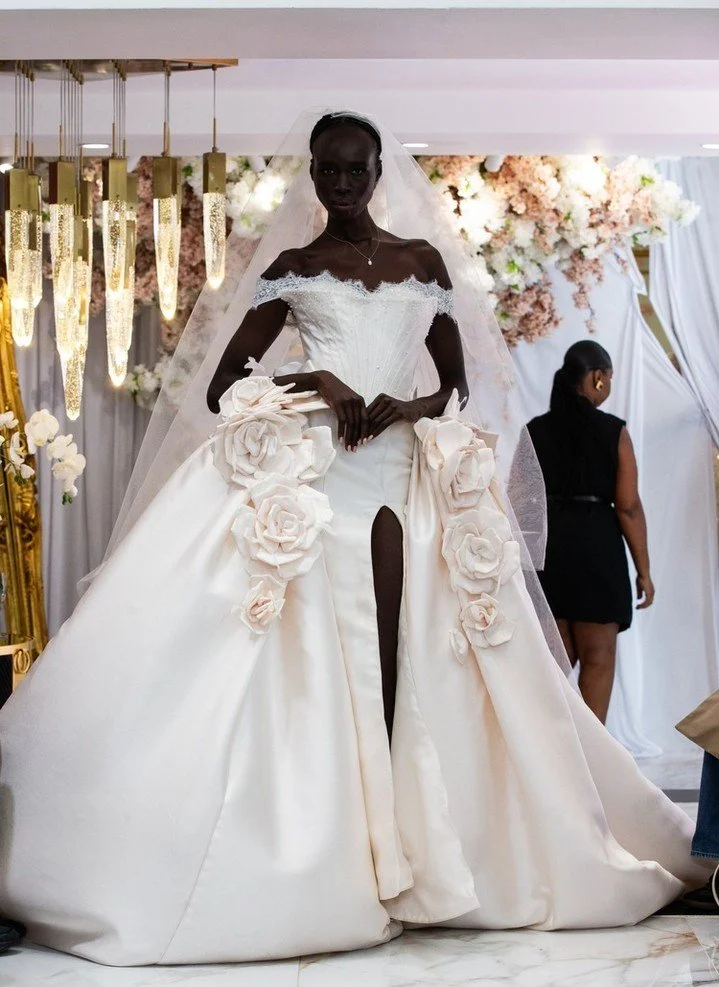 A lace sweetheart neckline is just the beginning of this magnificent gown. With dual 3D flowers that highlight a subtle split in the dress. Es&eacute; Az&eacute;nabor Fall 2026 Bridal Collection.

#NYLBFW #WeddingInspiration #BridalFashion #WeddingDr