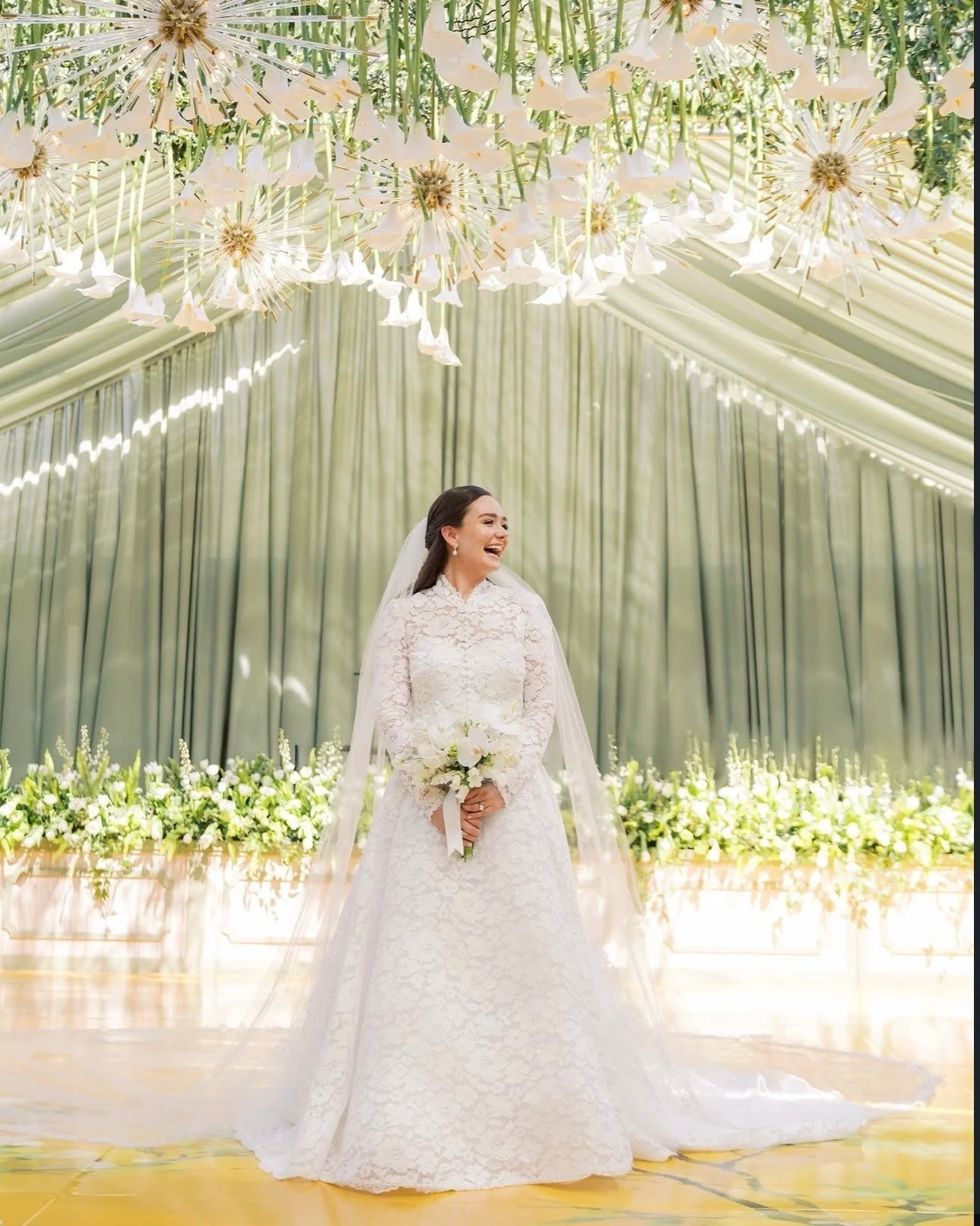 Sheer lace sleeves, intricate motifs, and a sweeping veil &mdash; @verdinbridal romance beneath a canopy of blooms.

 #NYLBFW #WeddingInspiration #BridalFashion #WeddingDress #BridalInspo #WeddingStyle #RomanticWedding #WeddingPhotography #BridalStyl