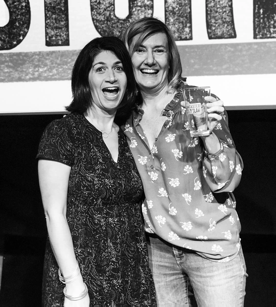 Shown above are emcee Jamie Beth Cohen with our April winner, Karen Foerstel, who won the prized pint glass for her ‘WTF?’ story.