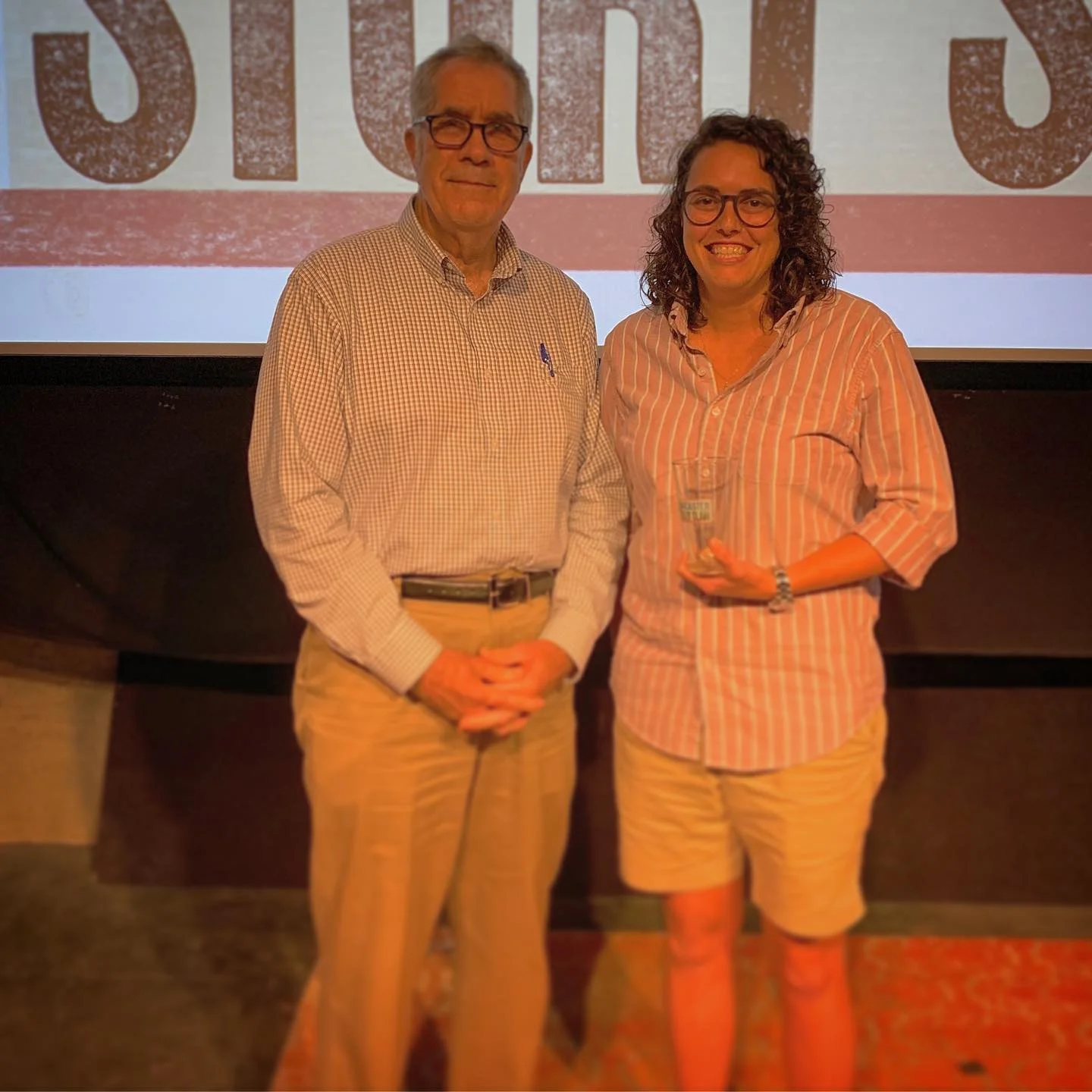 Emcee Tony Crocamo poses with Meghan Turk, the winner of this month’s ‘Warning Signs’ Story Slam and our prized pint glass. Photo credit: Kris Bradley of NameSpark.