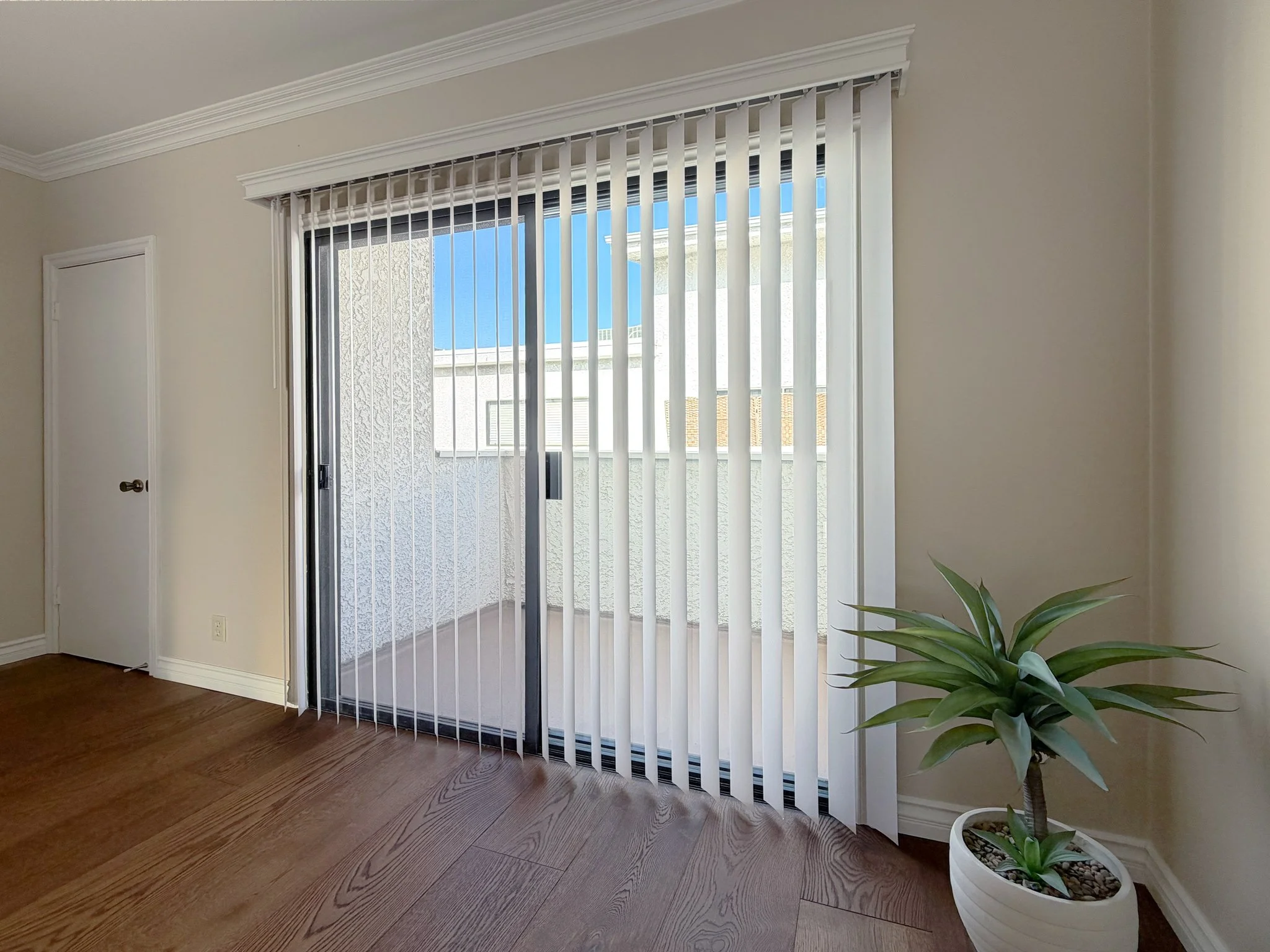   Sliding glass door with vertical blinds and coat closet  