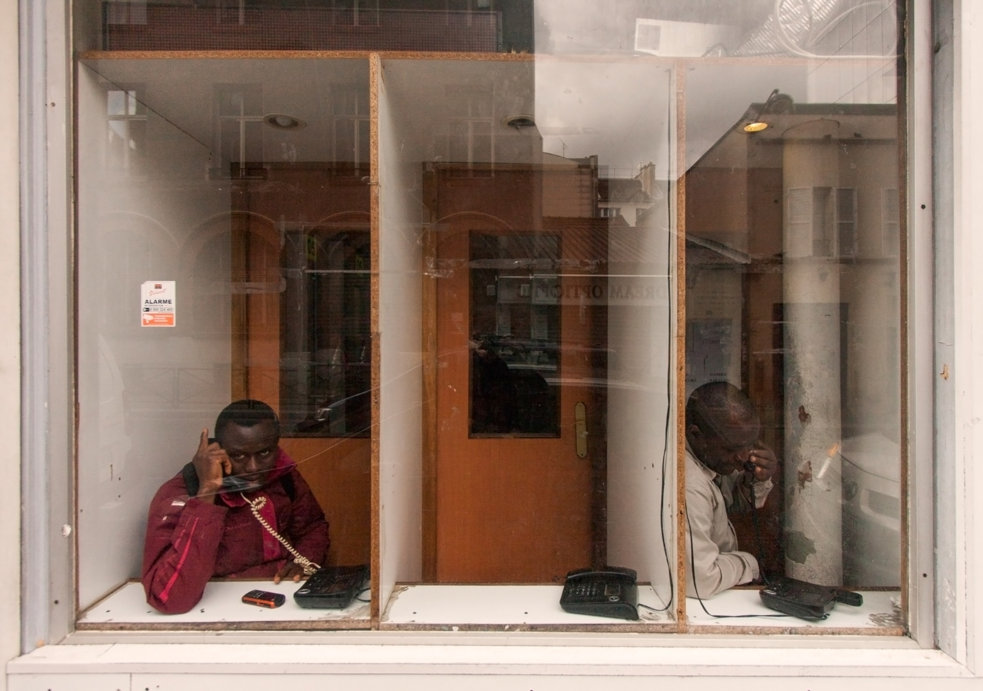 Shared telephone booth in Rue Doudeauville. Local residents rely on shared phones to contact relatives in their origin countries.