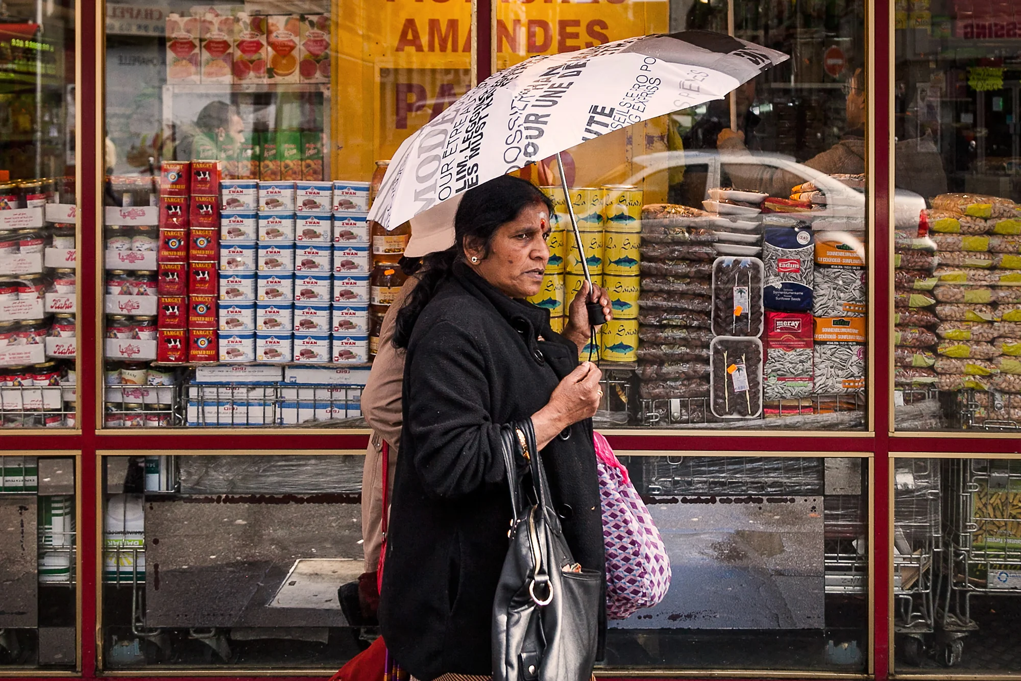 Indian woman walks by shops on Rue Marx Dormoy.