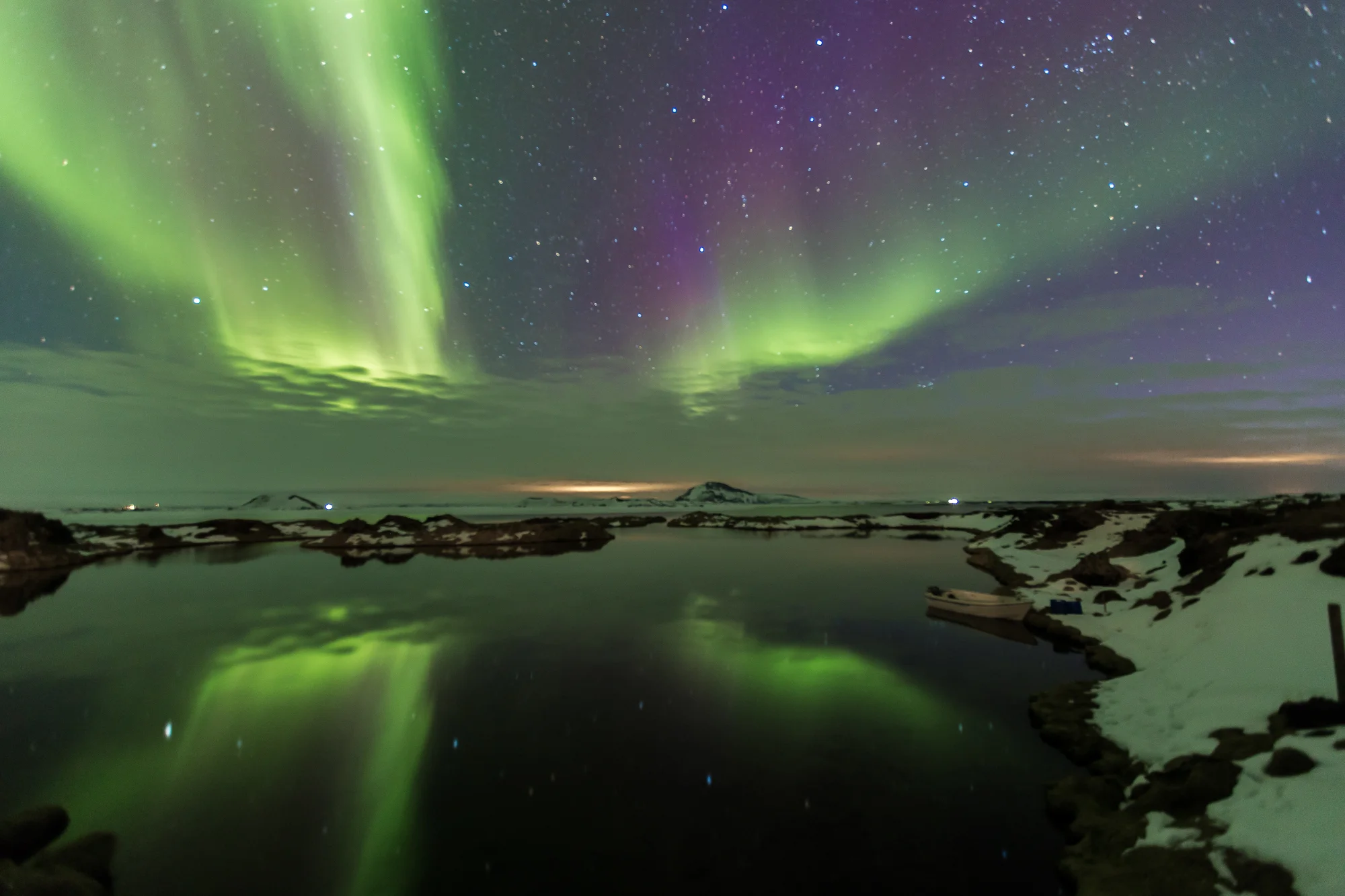 The northern lights shining over the peaceful pond in Myvatn