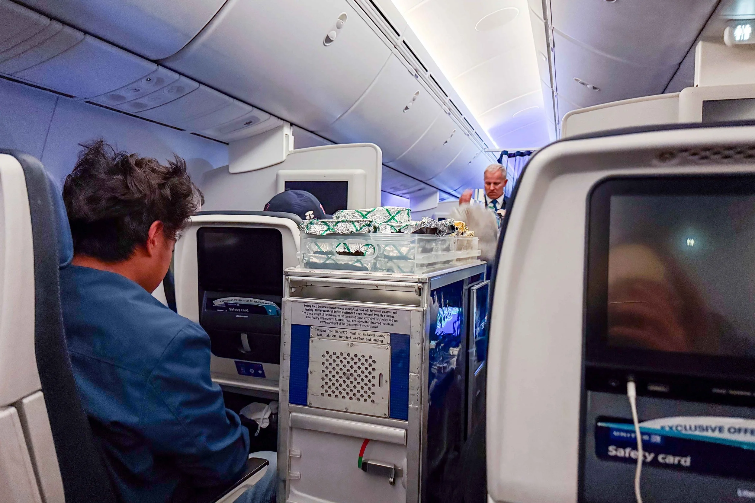 Flight attendant serving meals on United Airlines