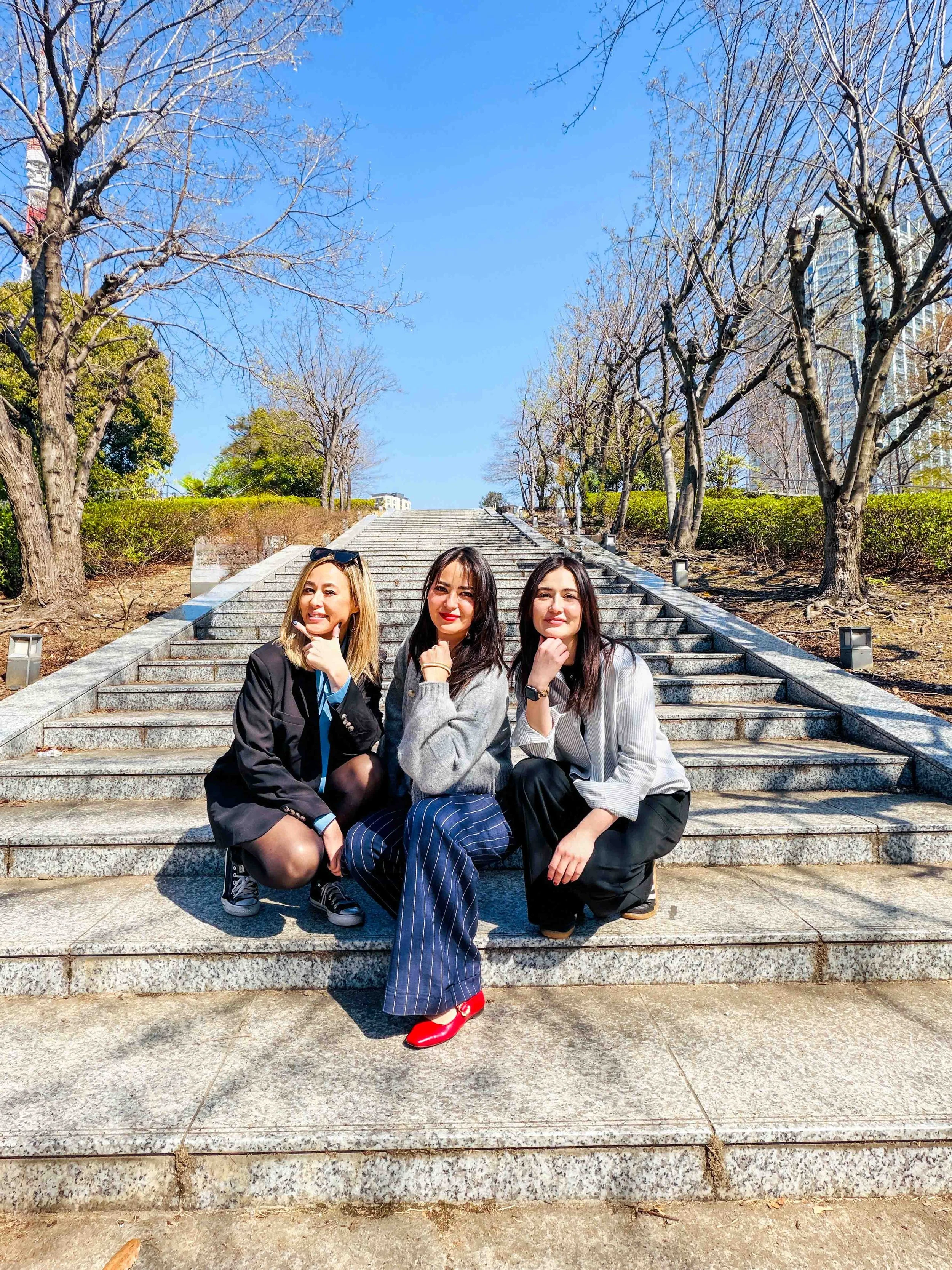Three sisters sitting on a long set of stairs