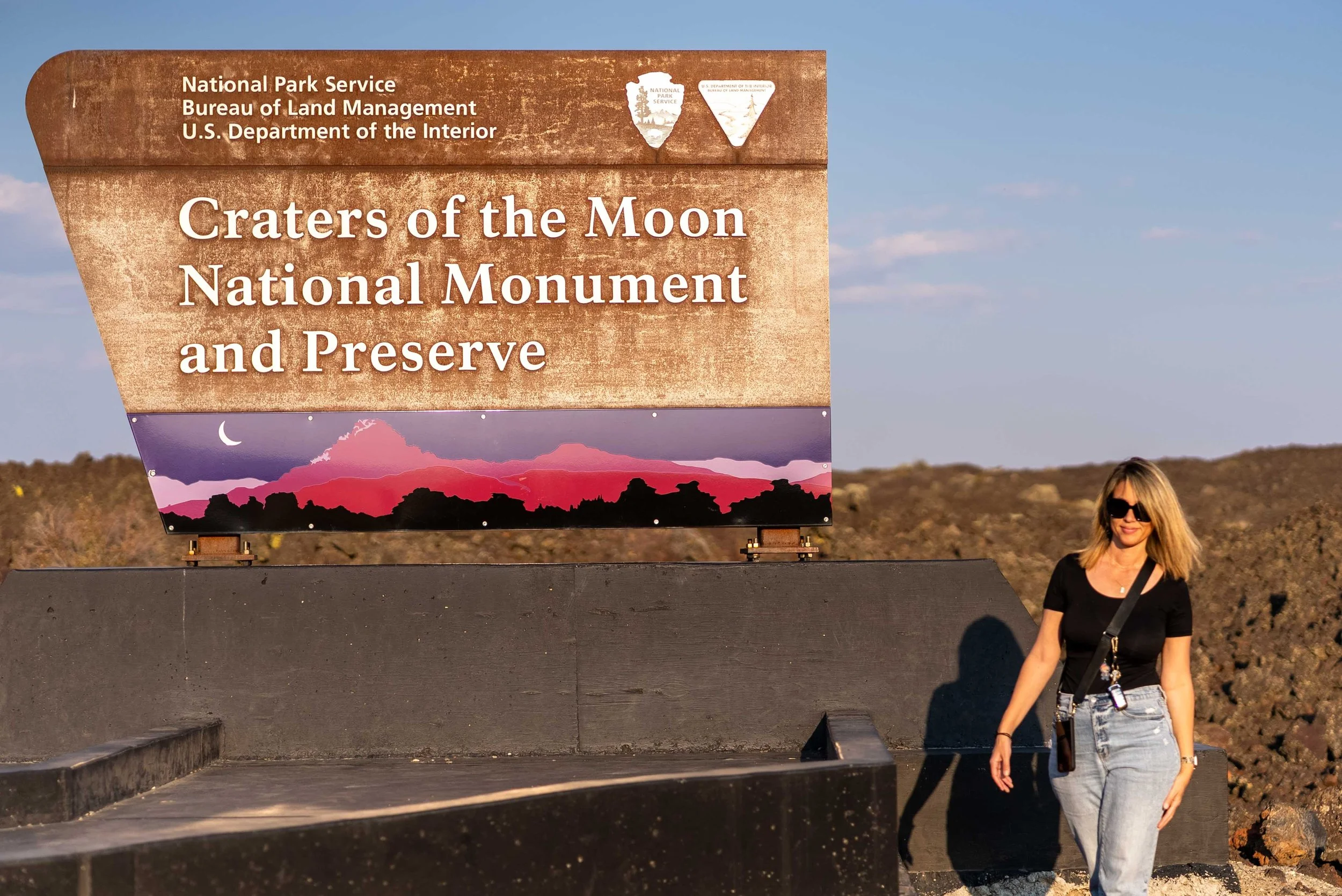 Standing by the Craters of the Moon sign