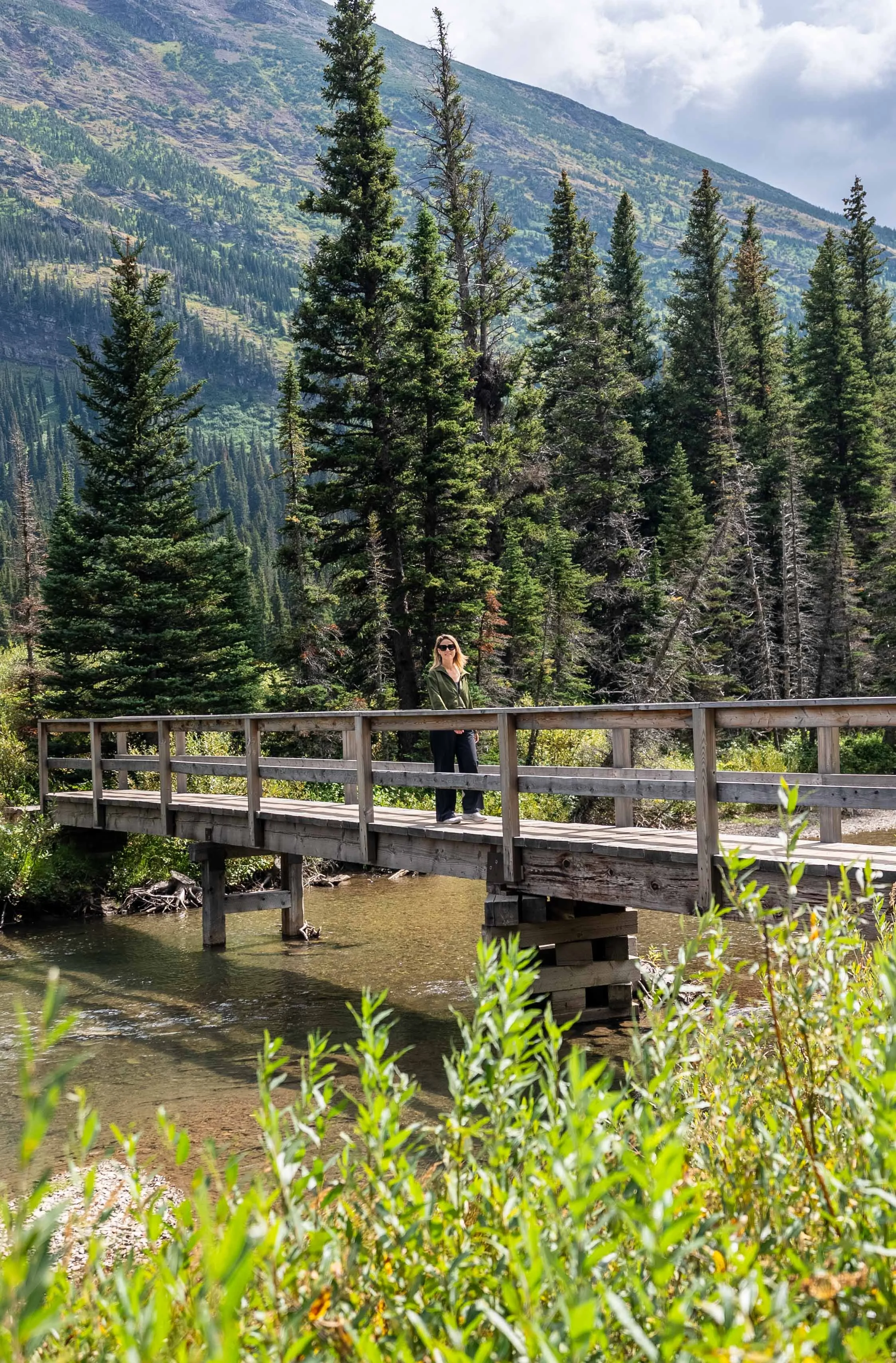 Walking across a cute bridge on the hike at Many Glacier
