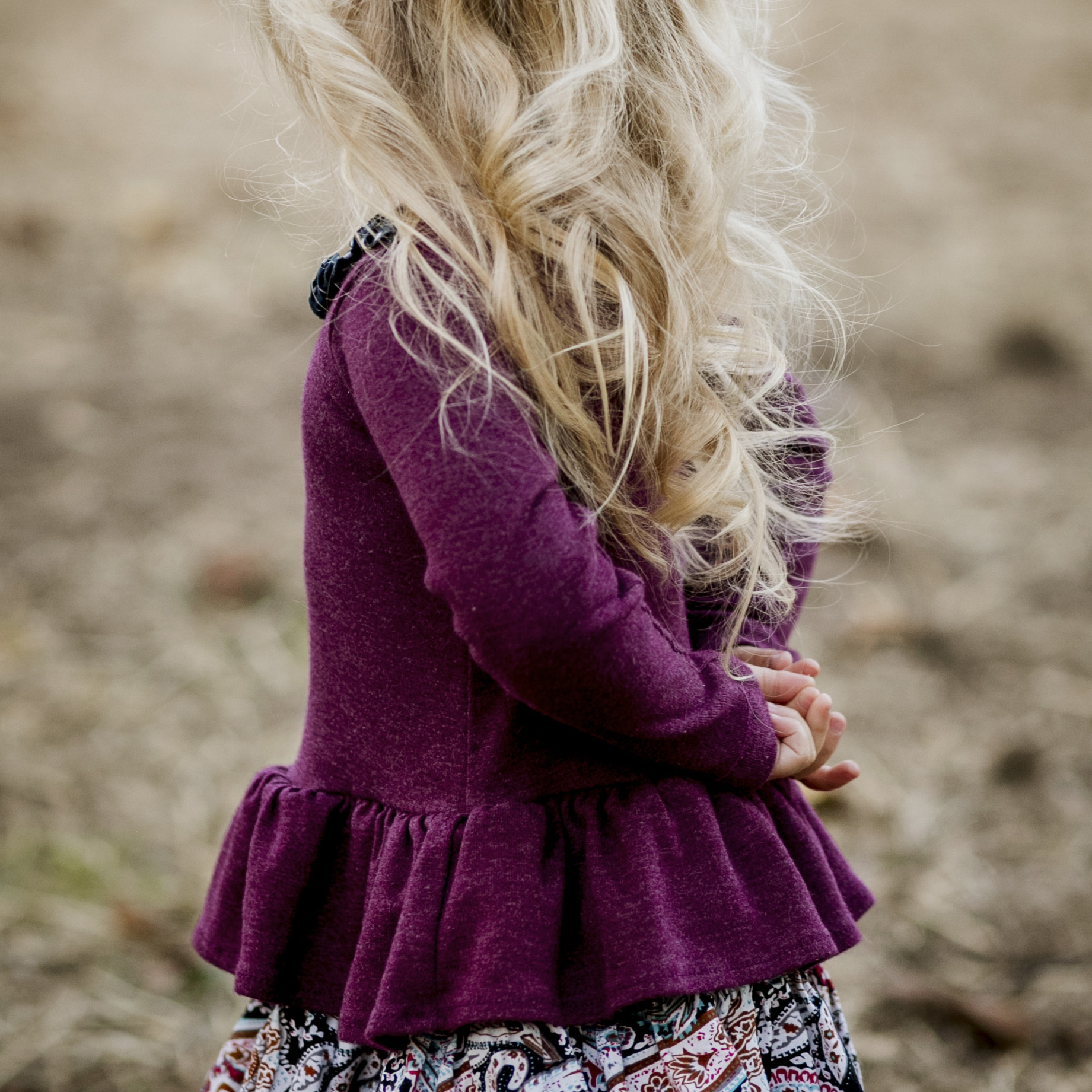 detail of little blonde girl with hands behind her back.jpg