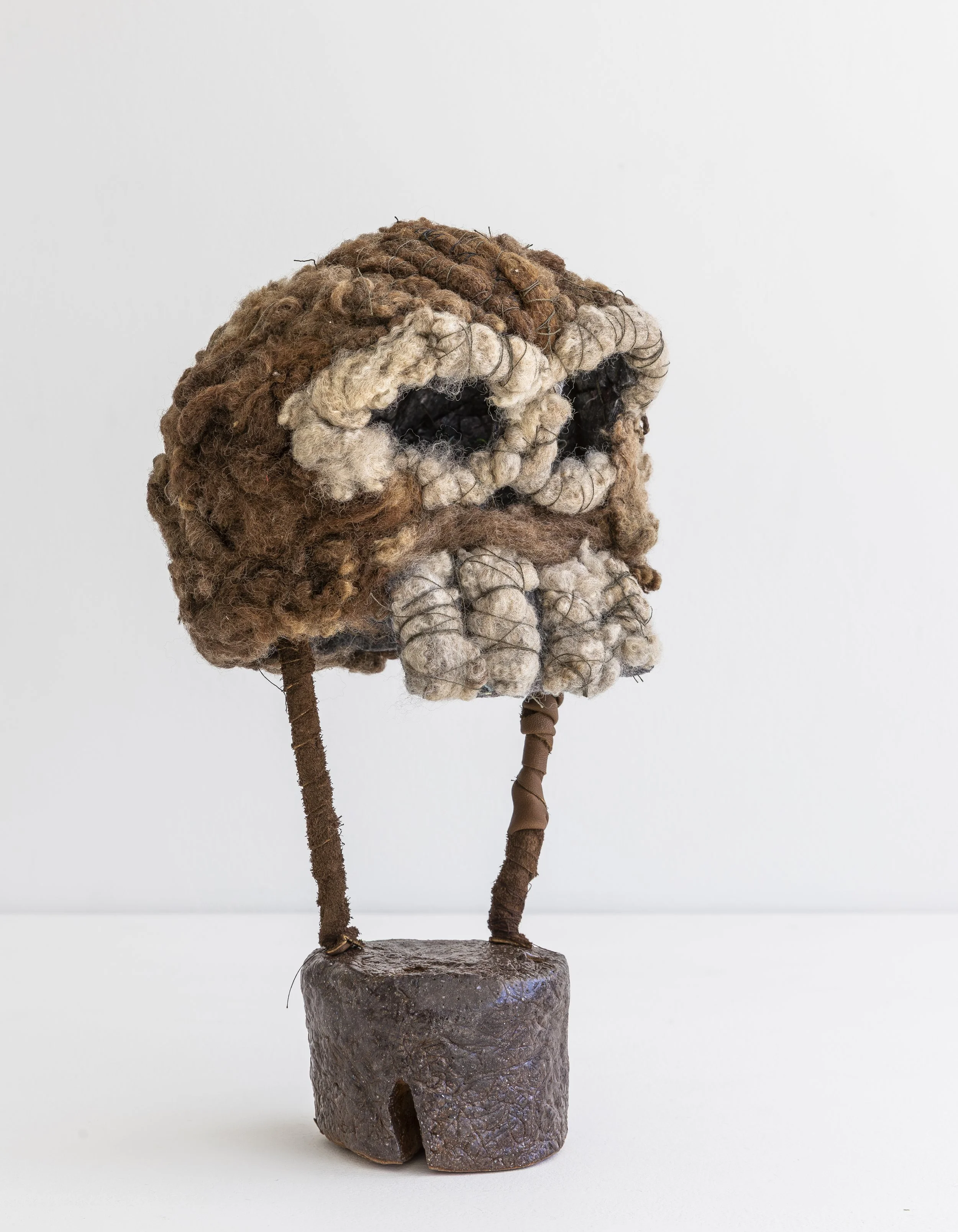   Untitled  (owl skull), 2024-5, wool (raw), felt (synthetic), thread, cowhide, aluminium wire, raku clay, glaze, 33 X 18 X 17 