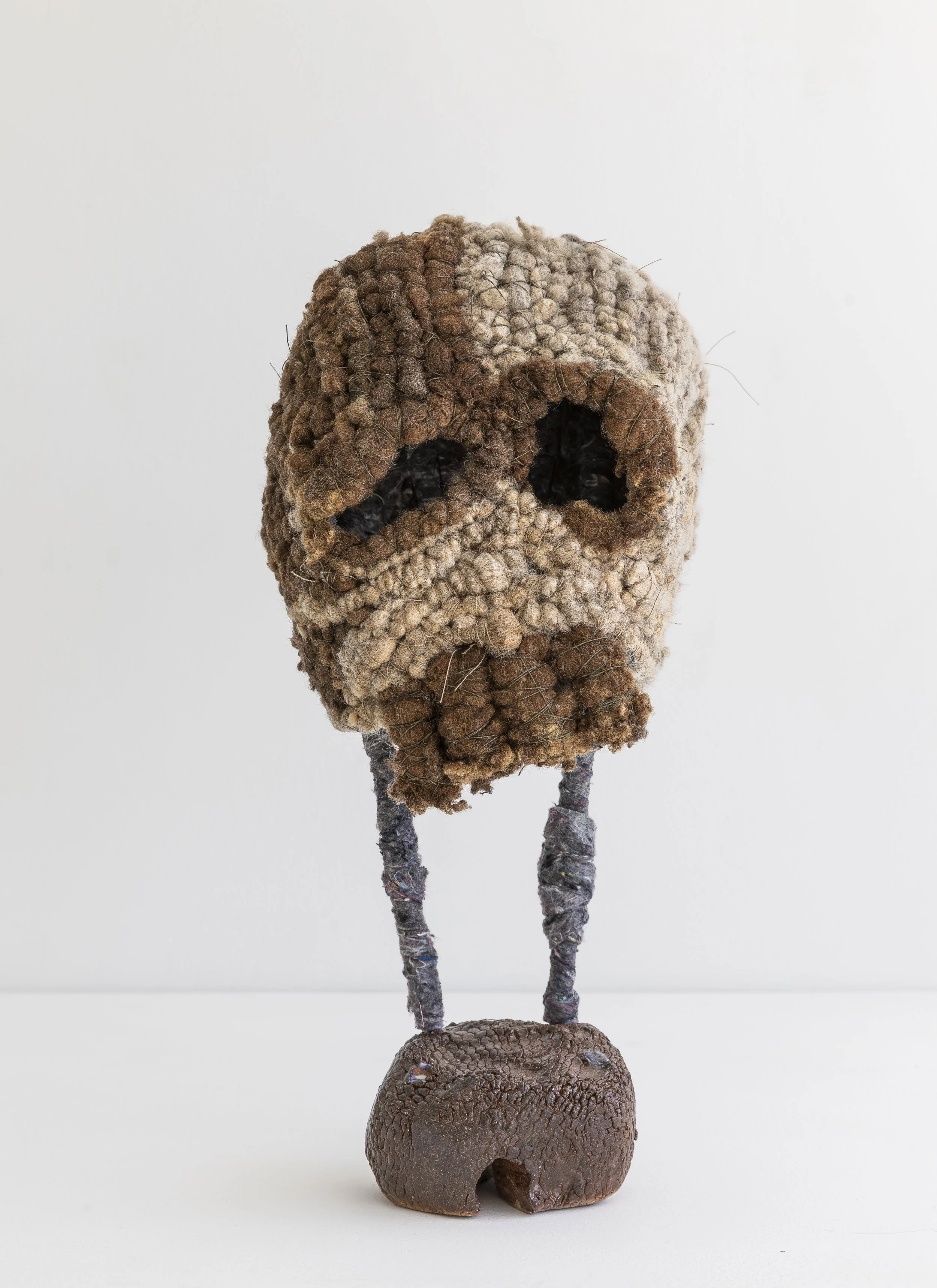   Untitled  (two tone skull), 2025, wool (raw), felt (synthetic), thread, aluminium wire, raku clay, glaze, 39 X 19 X 16   