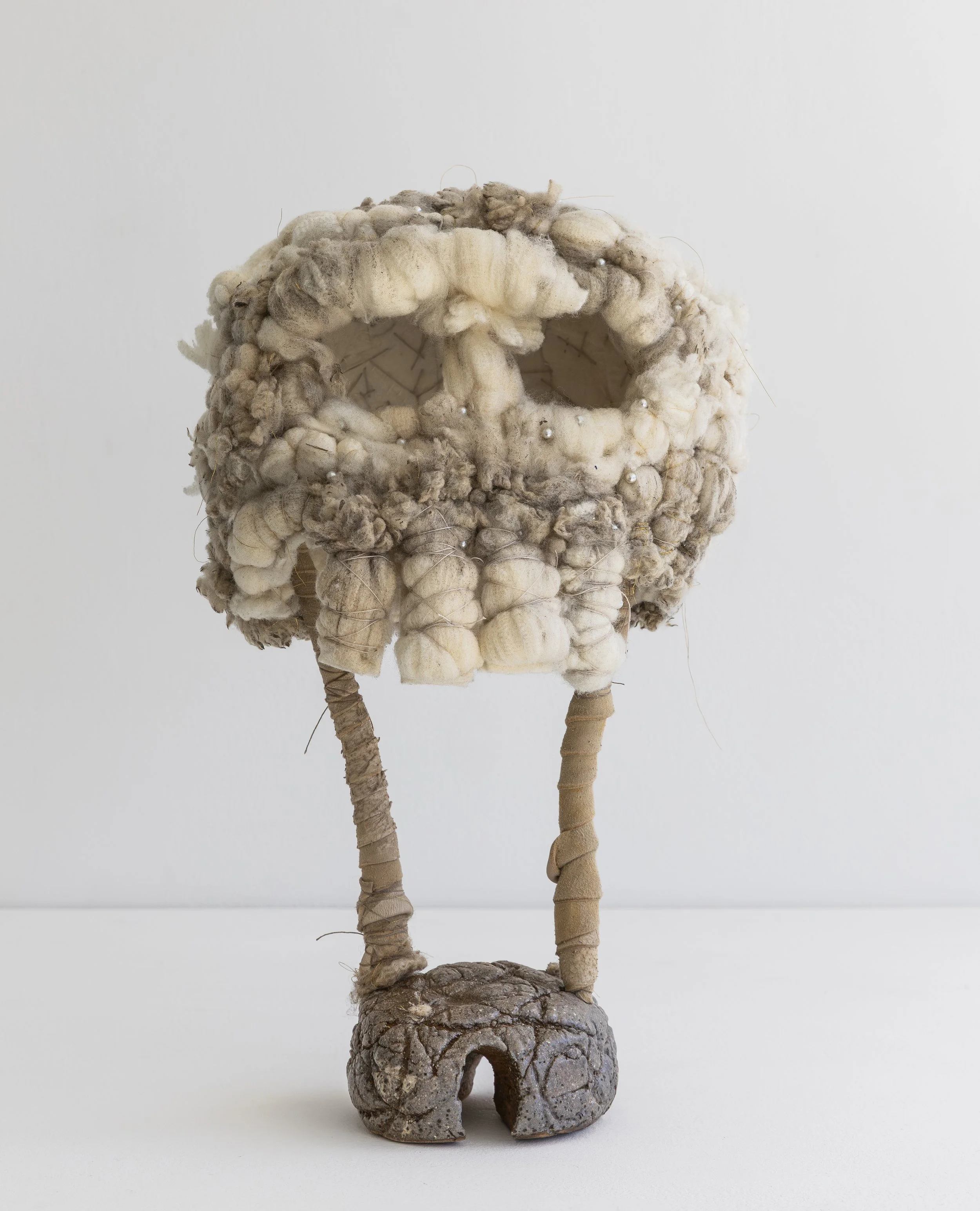   Untitled  (pearl skull), 2025, wool (raw), felt (synthetic), thread, gold thread, pins, beads, deer leather, aluminium wire, white raku clay, glaze, 36 X 23 X 20 