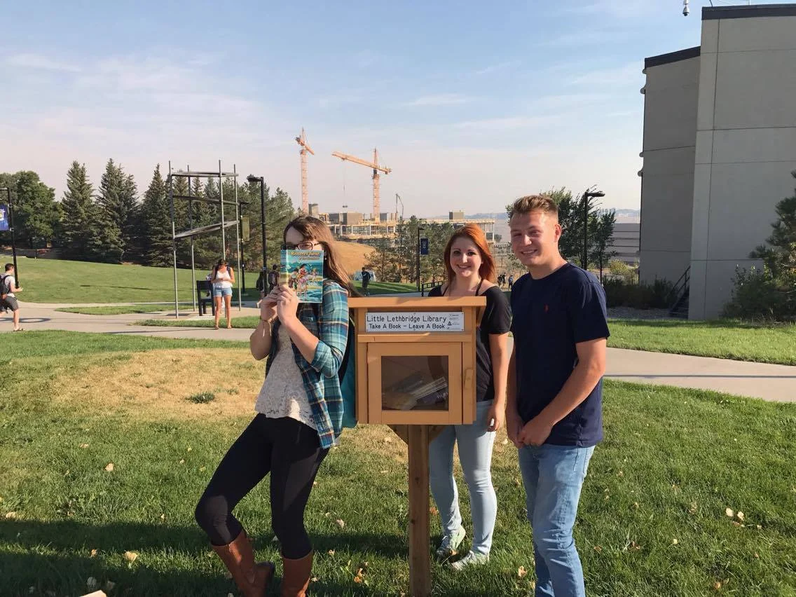 Kaleigh (left), Emily (middle), and Spencer (right), posing next to the Little Lethbridge Library in the bus loop. They were all very happy to cross another item off their scavenger hunt checklist! 