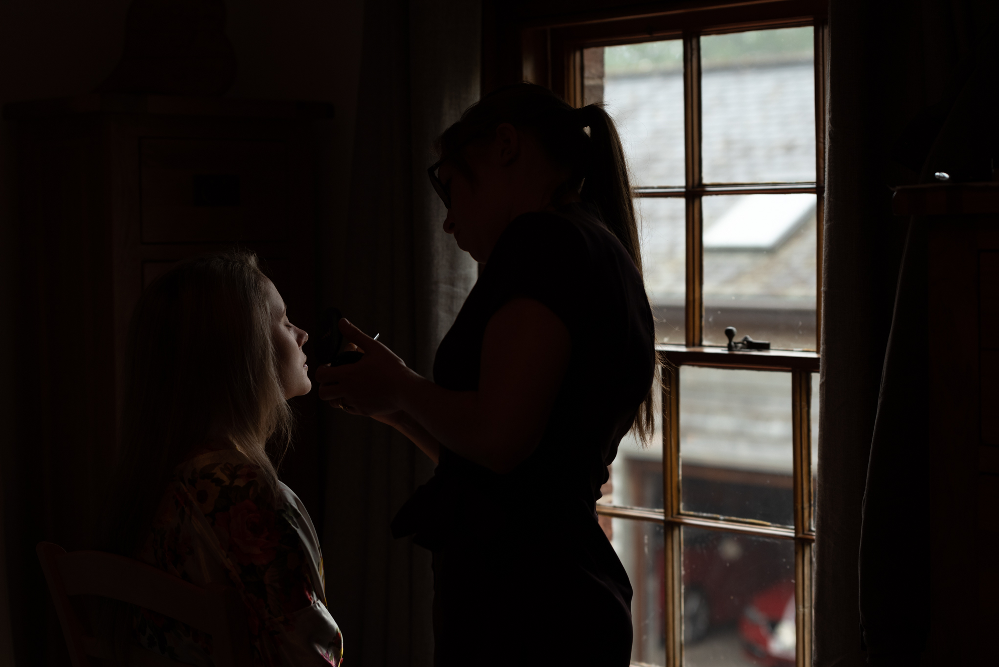 Brides make-up being done in window - Powys Wedding Photography