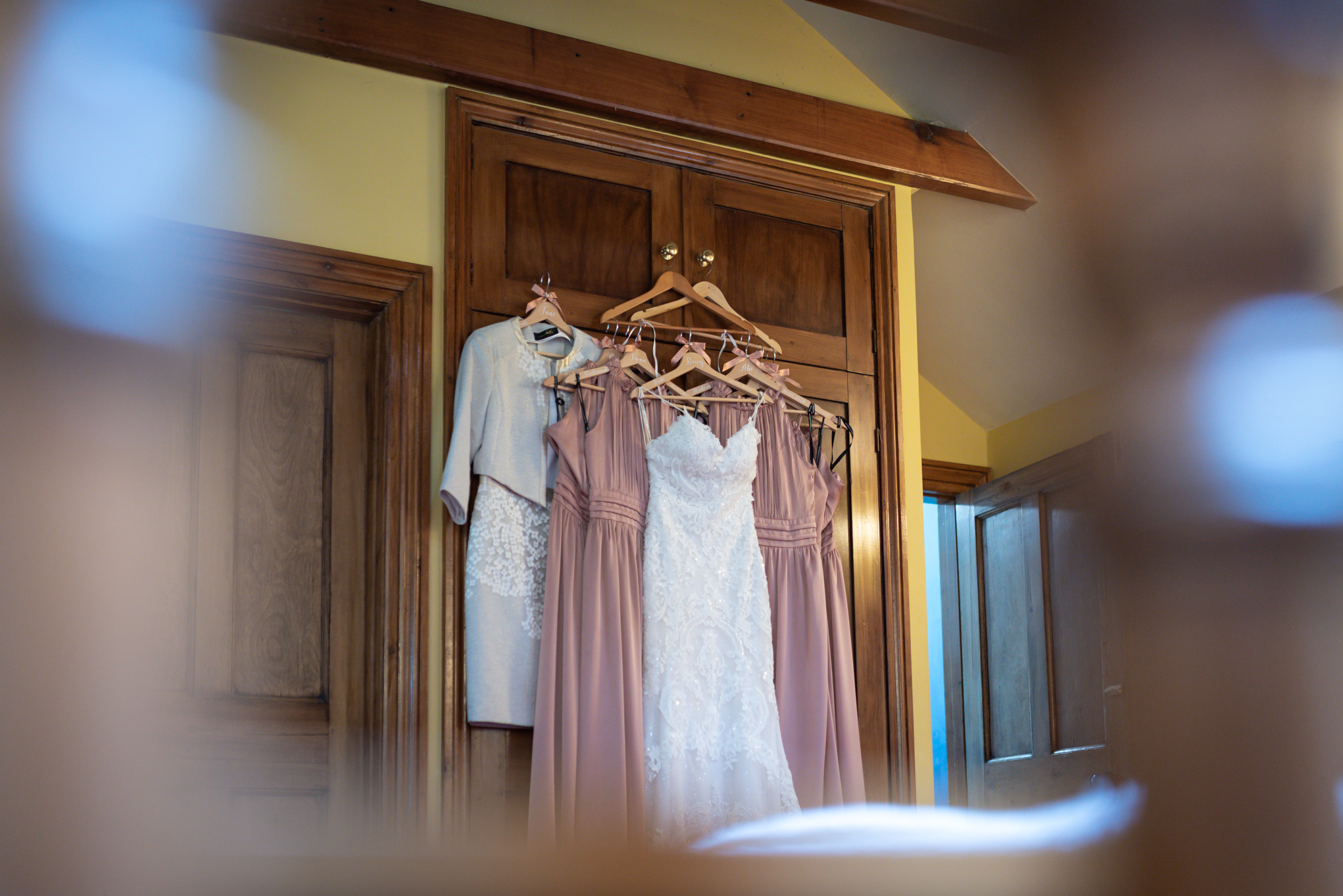 Wedding dress and bridesmaids dresses hanging up - Powys Wedding Photography