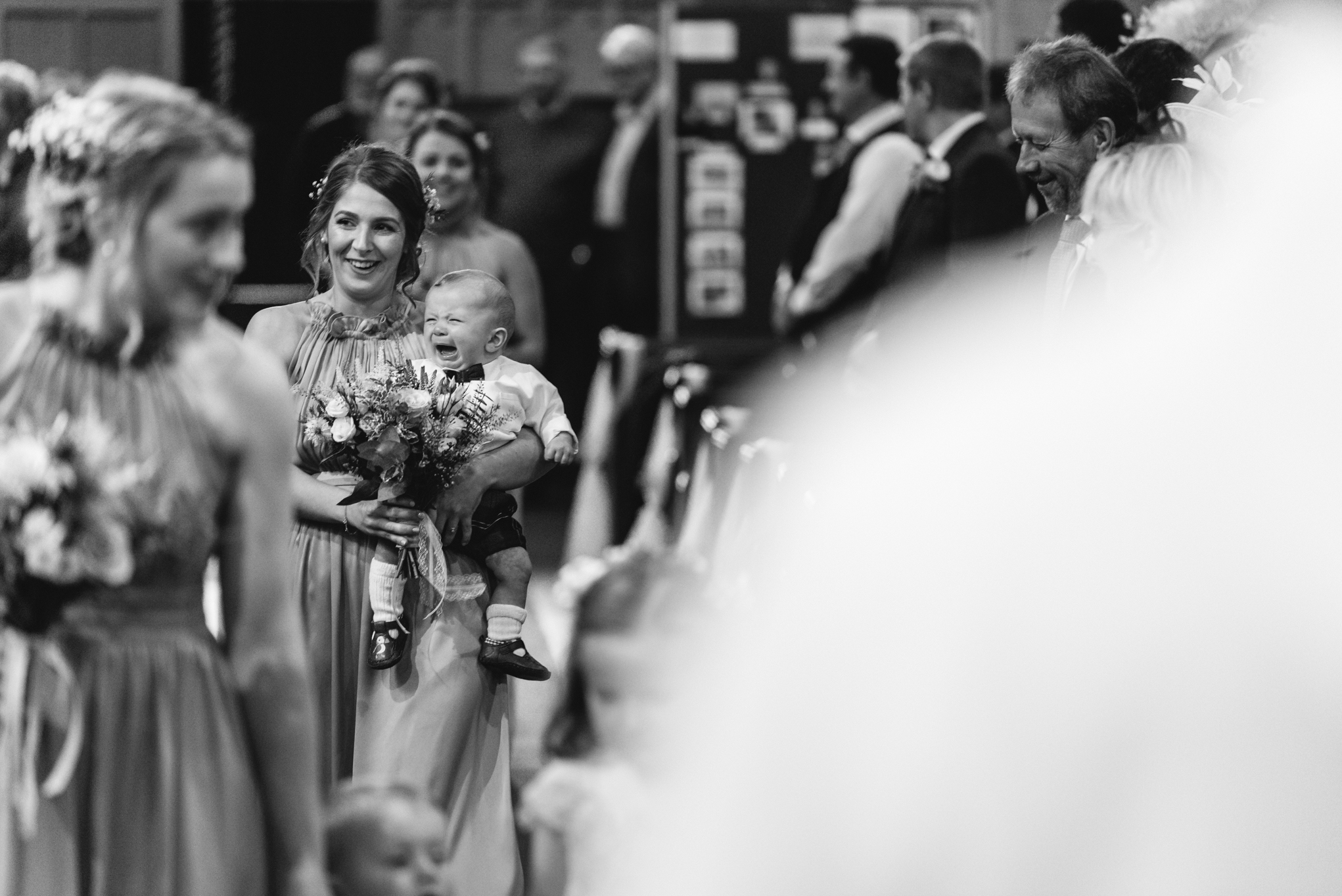 bridesmaid and crying baby walking down aisle - Powys Wedding Photography