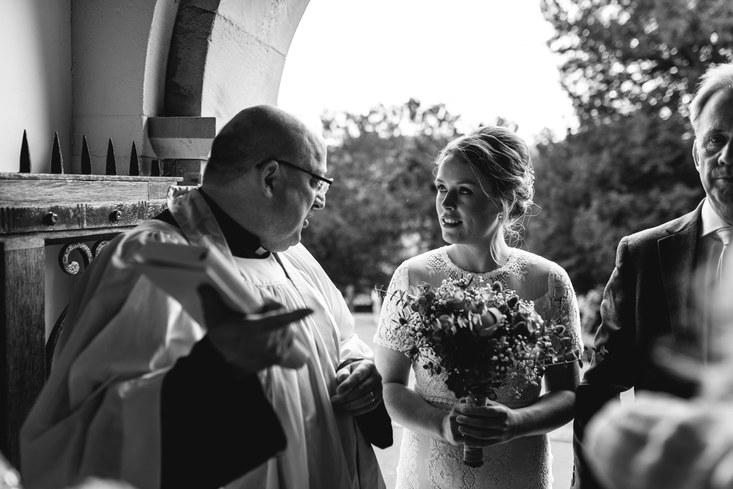 Bride talking to vicar at church