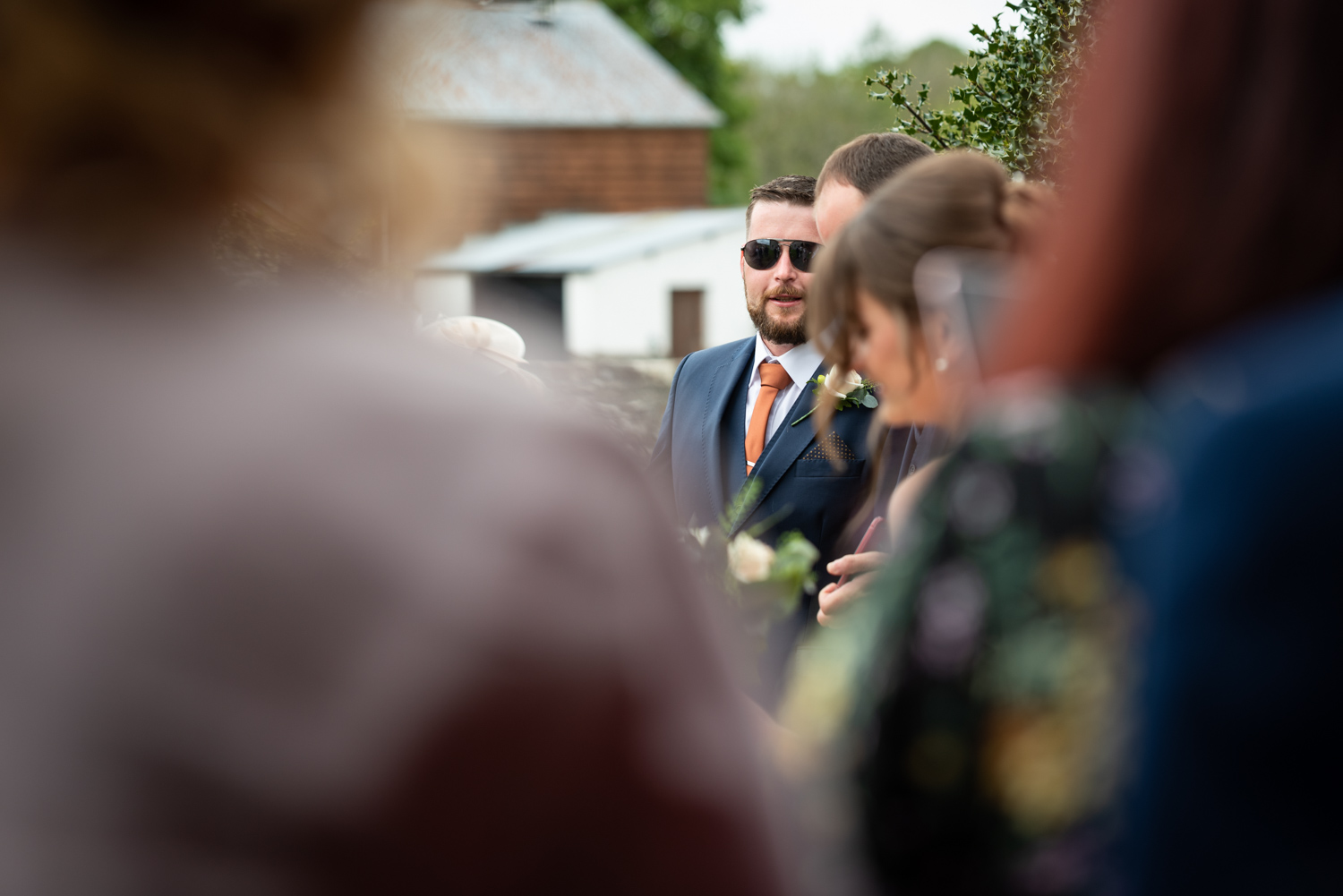 Best man talking to other wedding guests