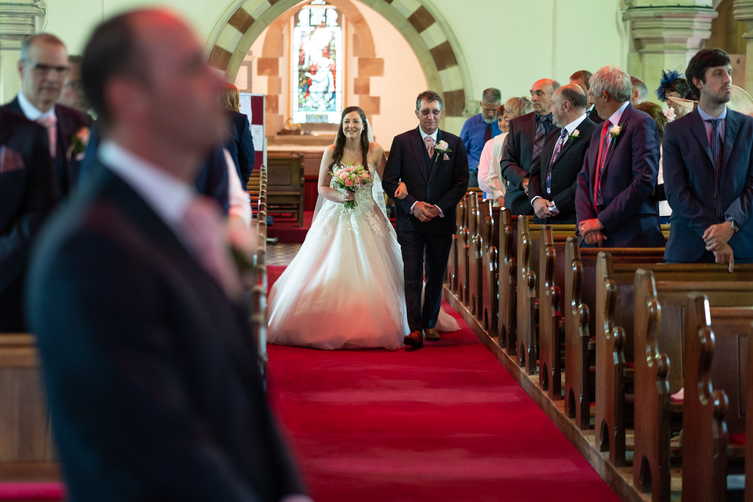 Bride walking down church aisle