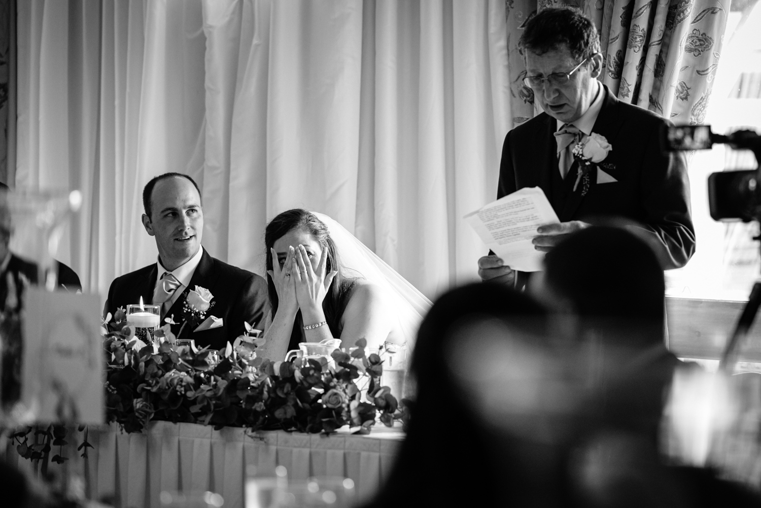 Bride hiding face during wedding speeches
