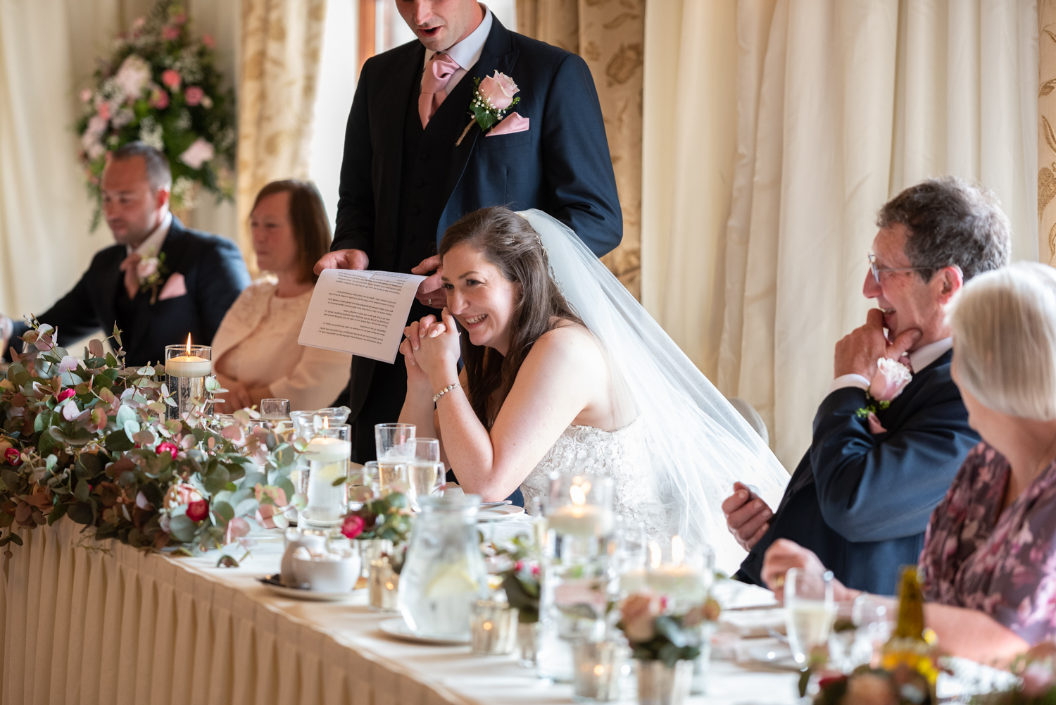Bride laughing during wedding speeches