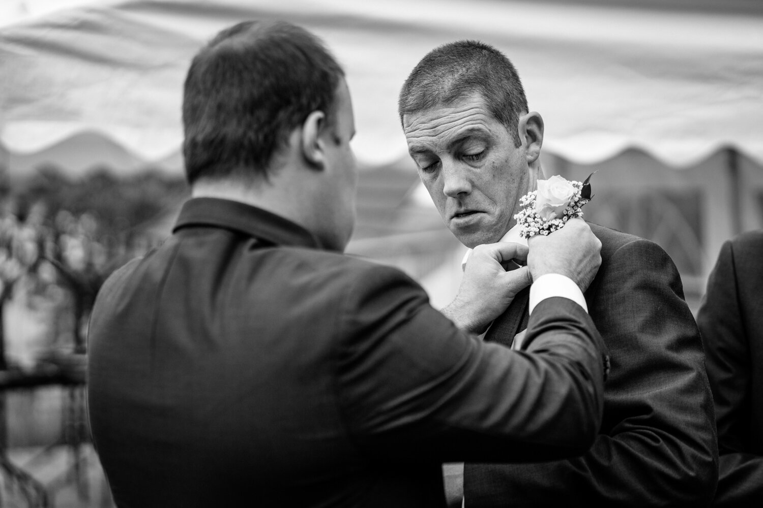 Usher helping groom with button hole