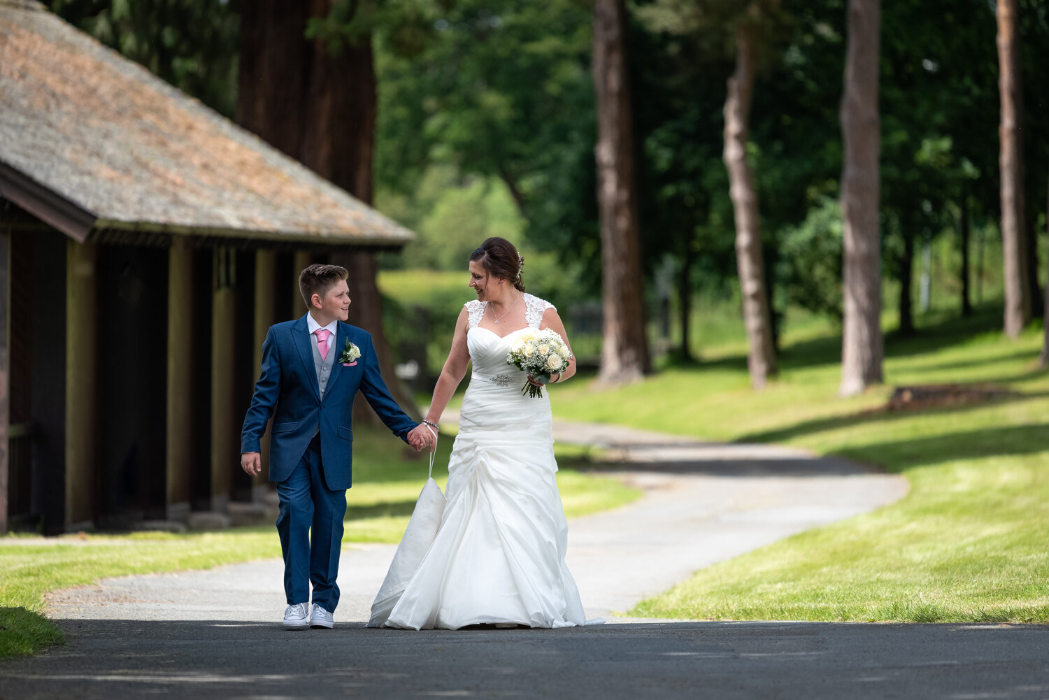 Bride and son walking to wedding ceremony hand in hand