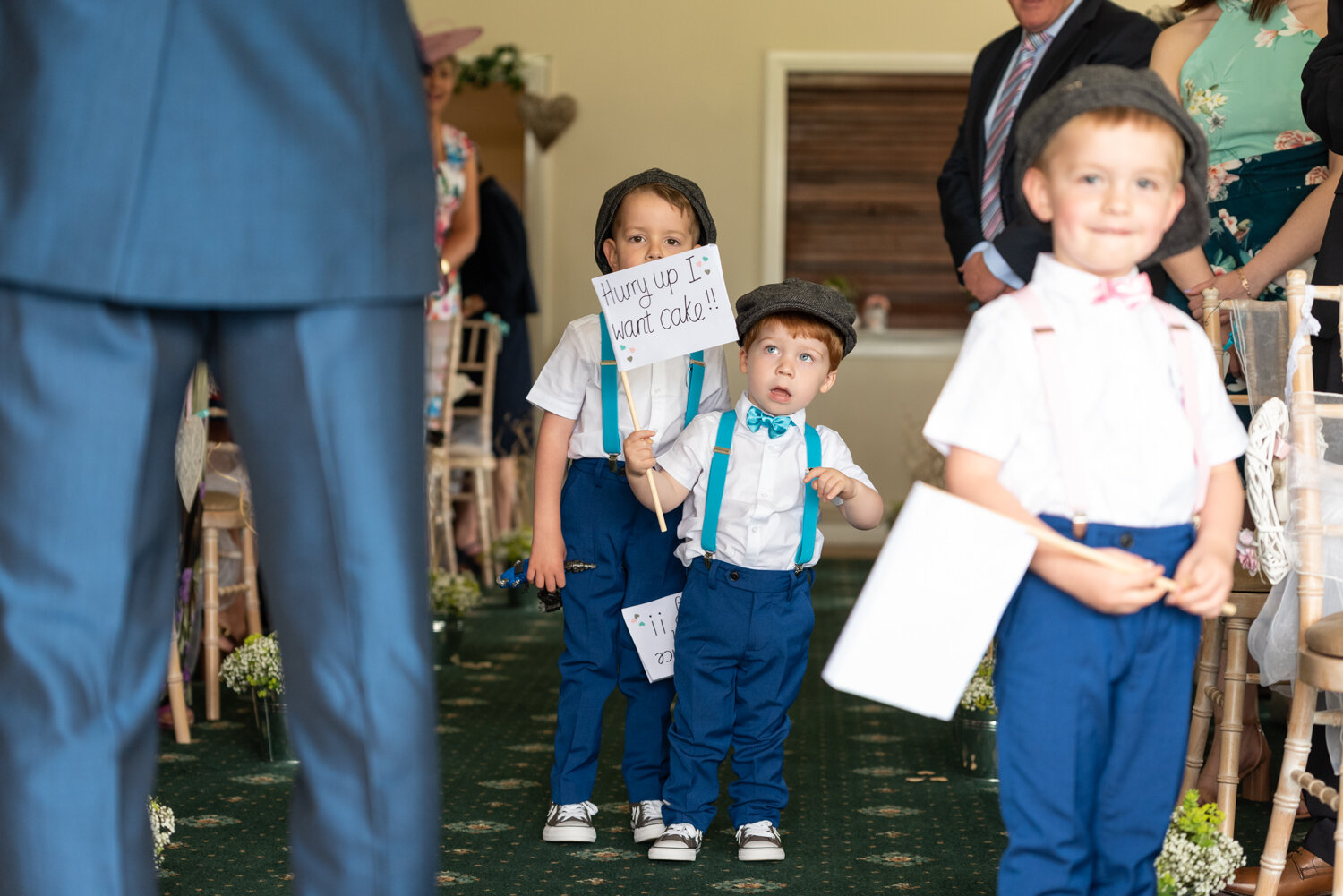 Paige boys walking down the aisle with signs