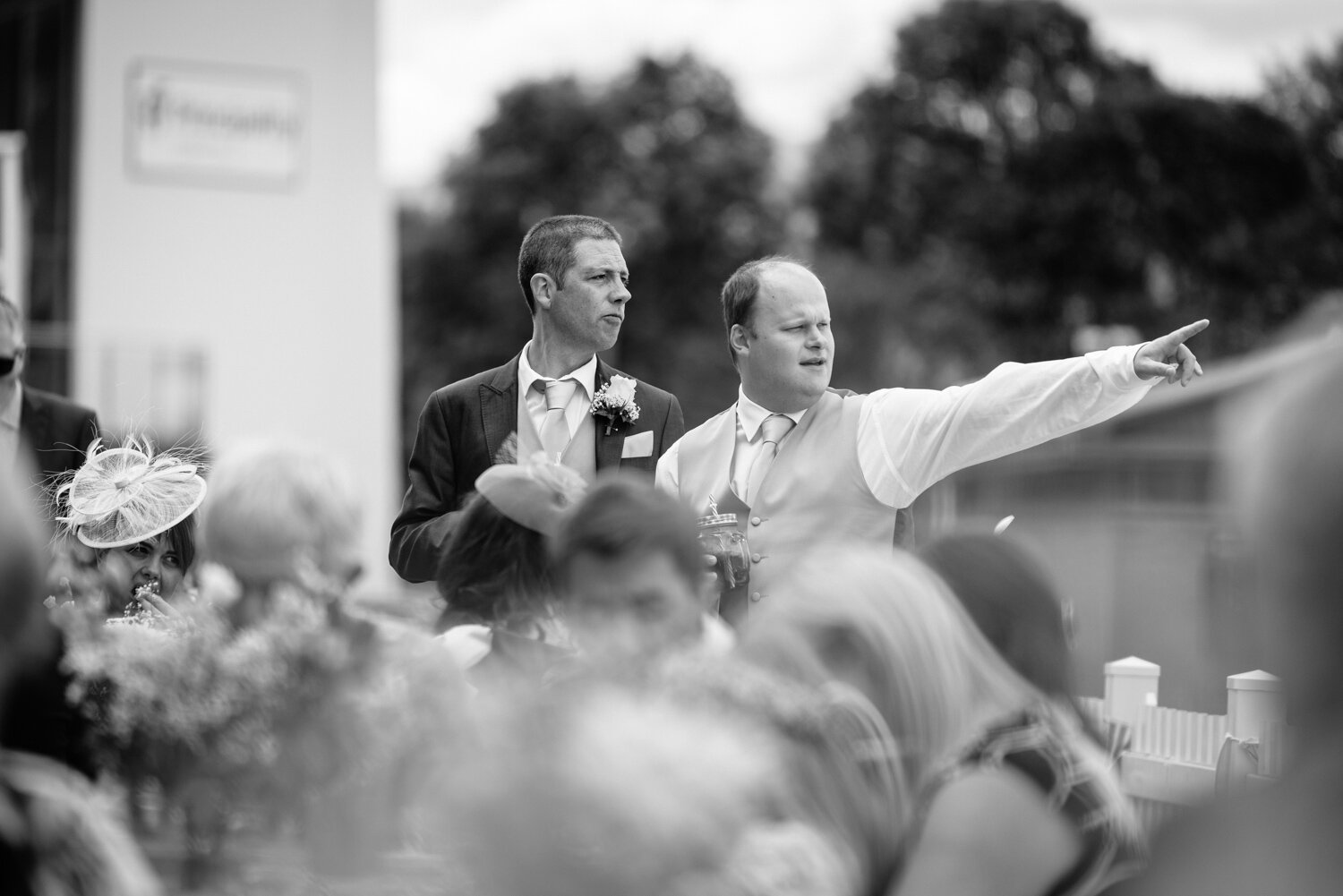 Groom and usher pointing to the distance