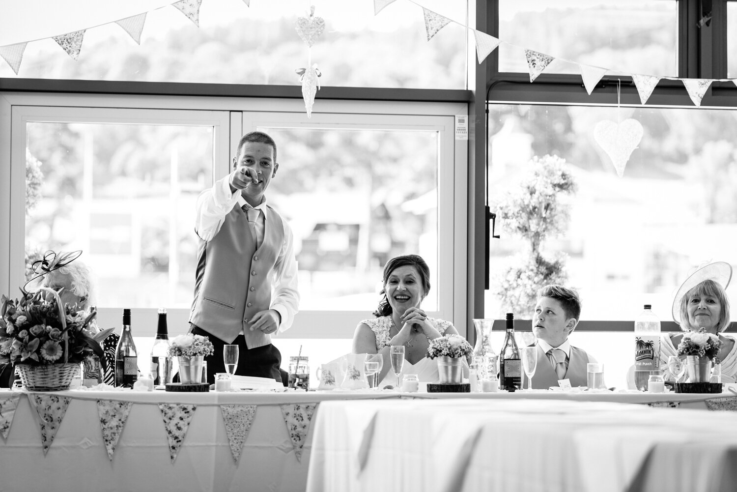 Groom pointing at photographer
