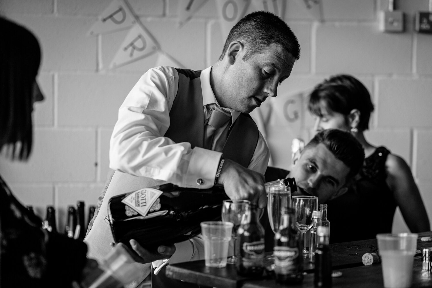 Groom pouring huge bottle of Prosecco