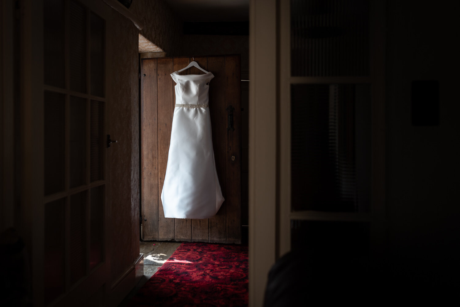 Wedding dress hanging on farmhouse door