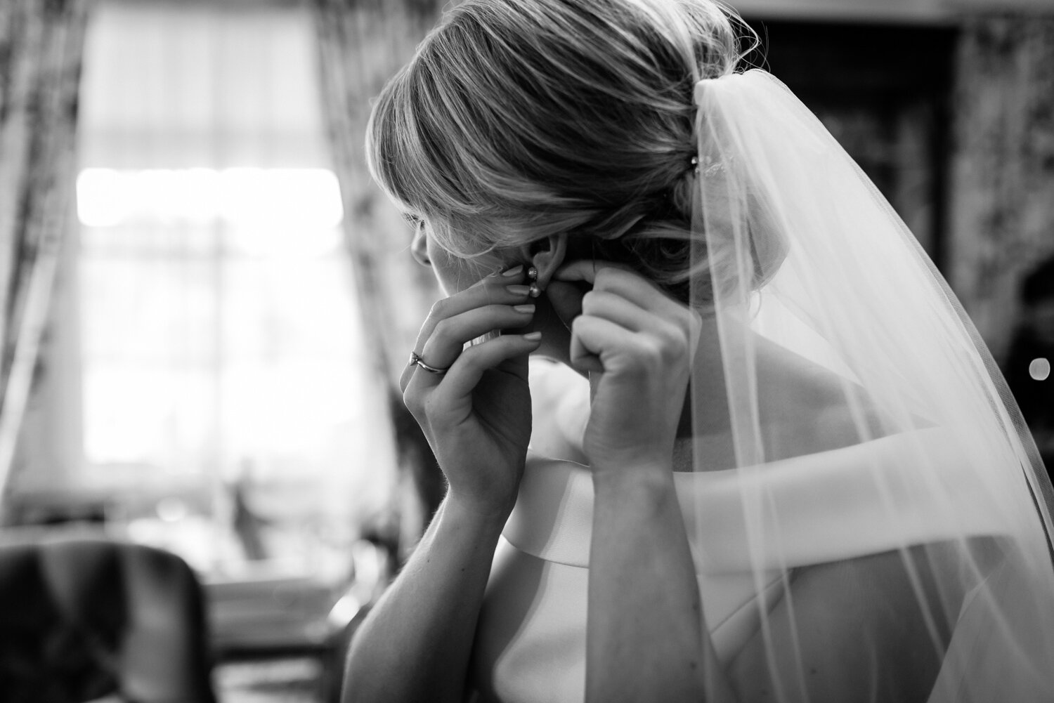 Wedding bridal preparation earrings being put in