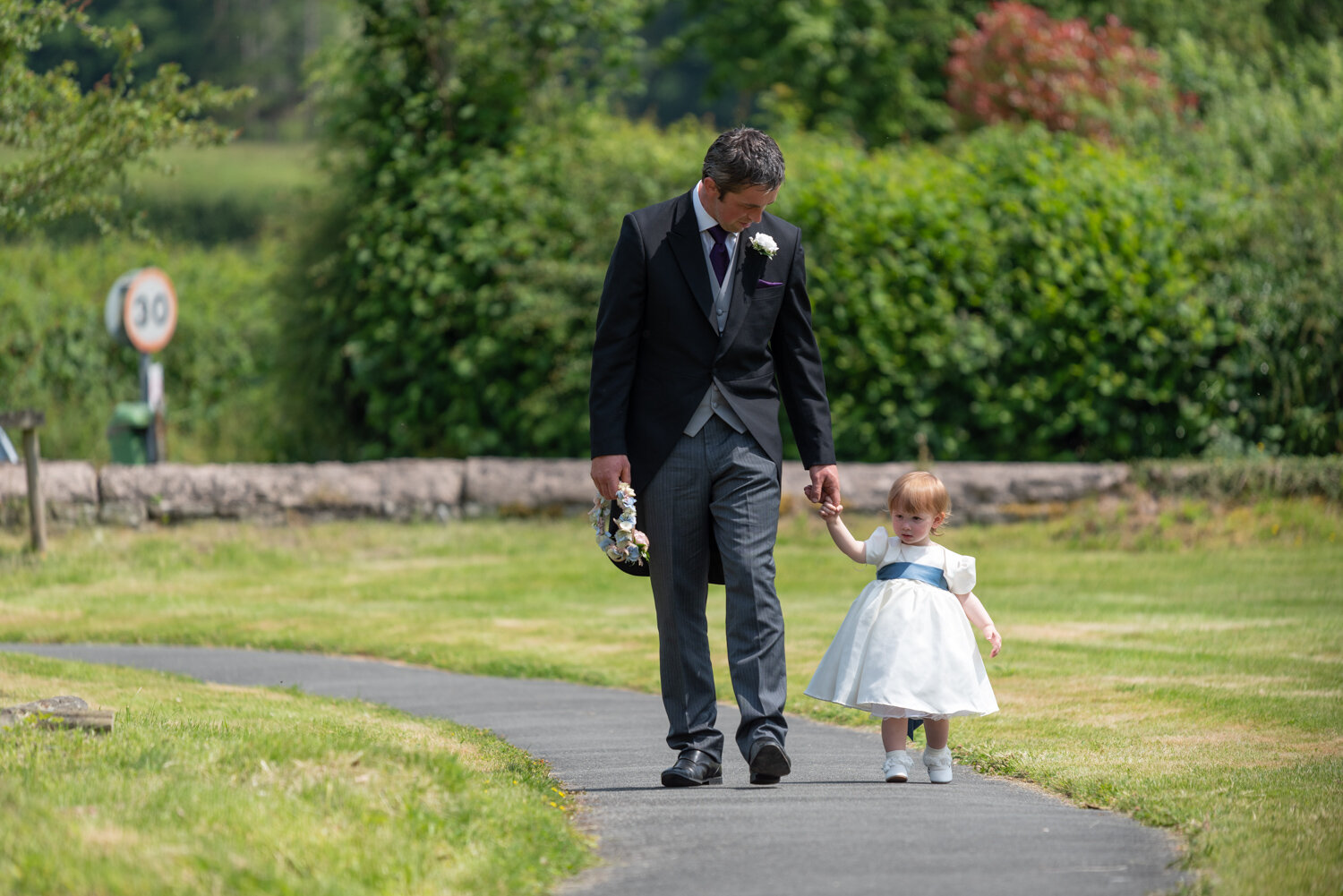 Father and baby walking up path to church in Glasbury