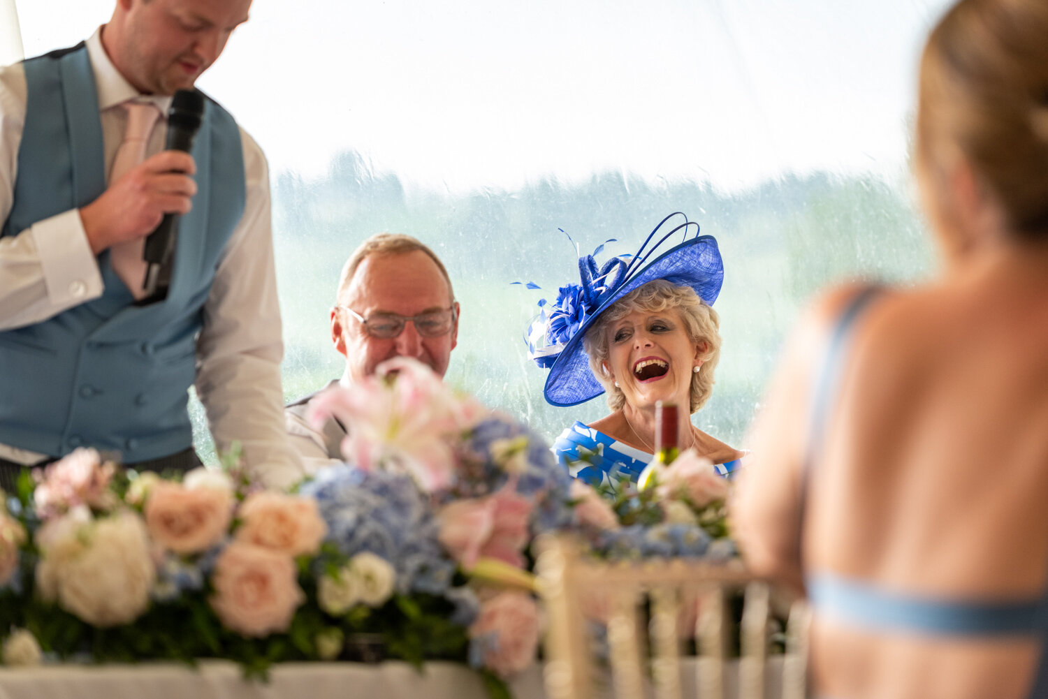 Mother of bride laughing at wedding speech