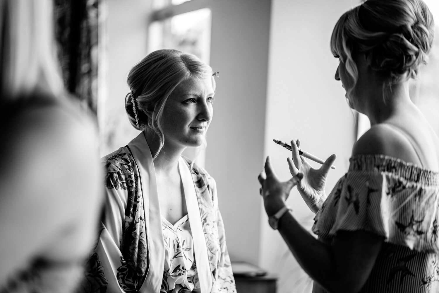 Bridesmaid talking to make-up artist