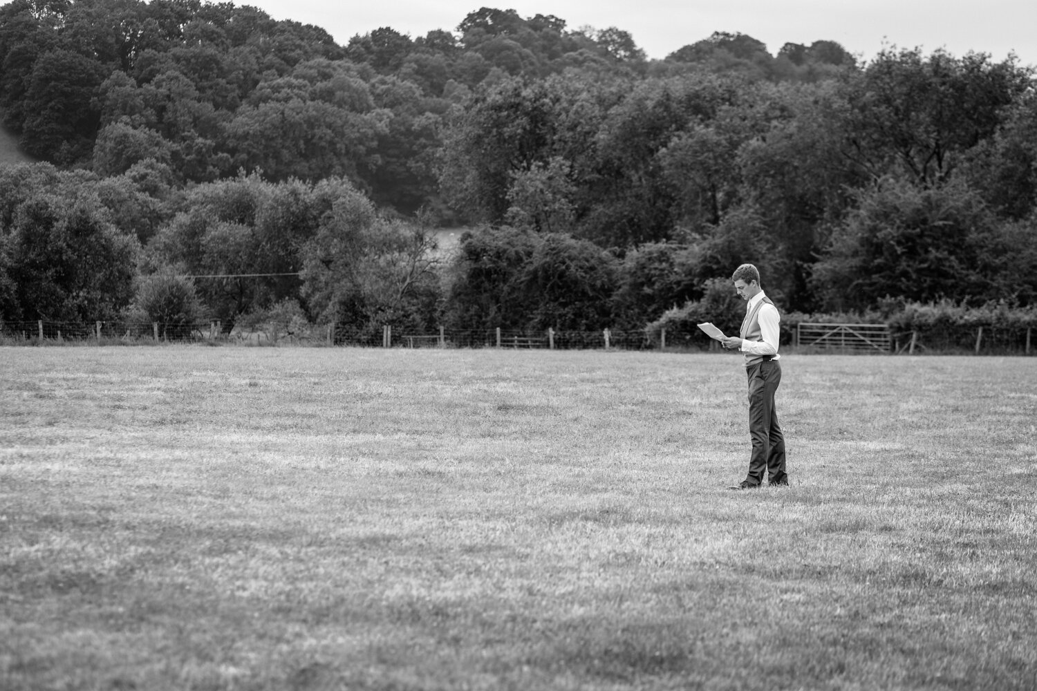 Best man practicing speech alone in field at Powys wedding