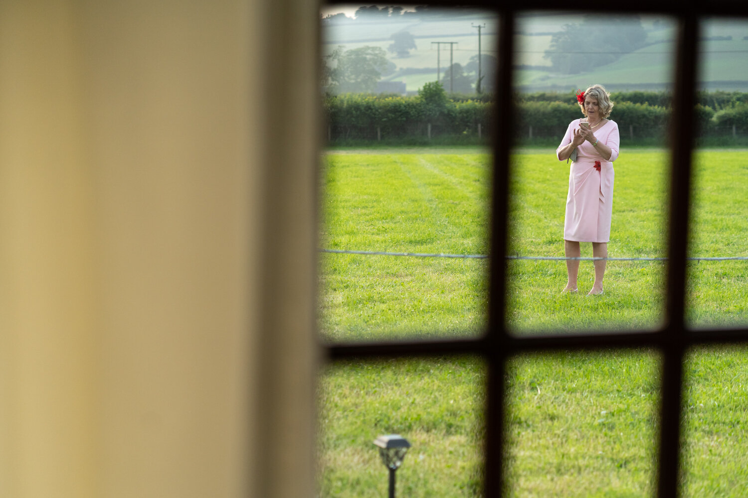 Wedding guest using phone in field