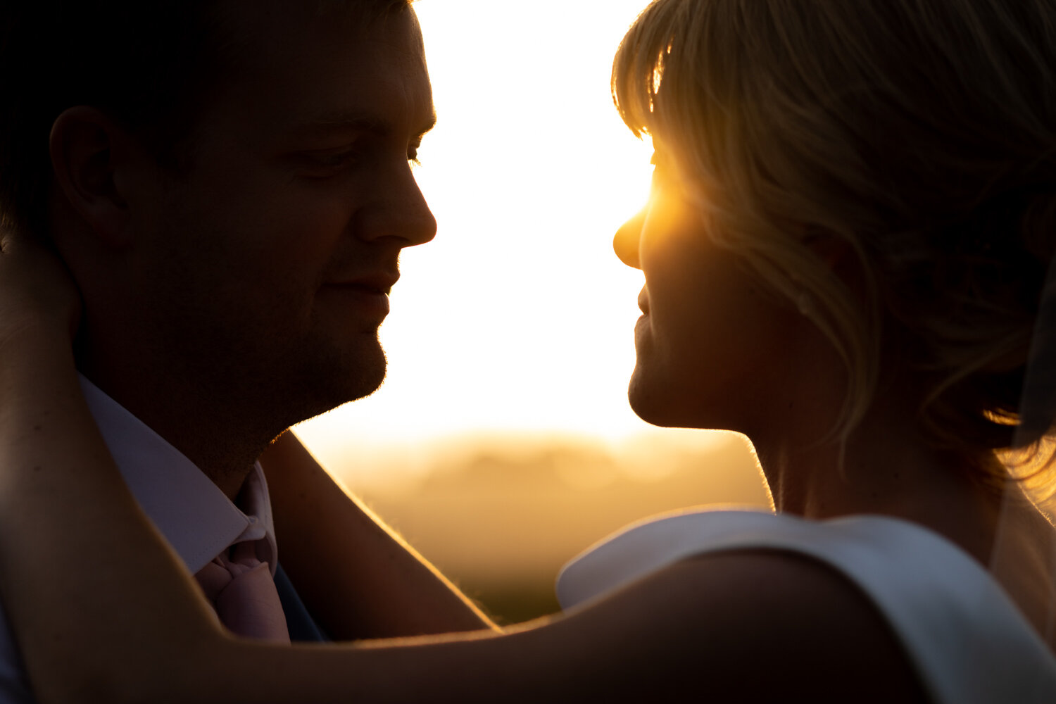 Golden hour silhouette of bride and groom