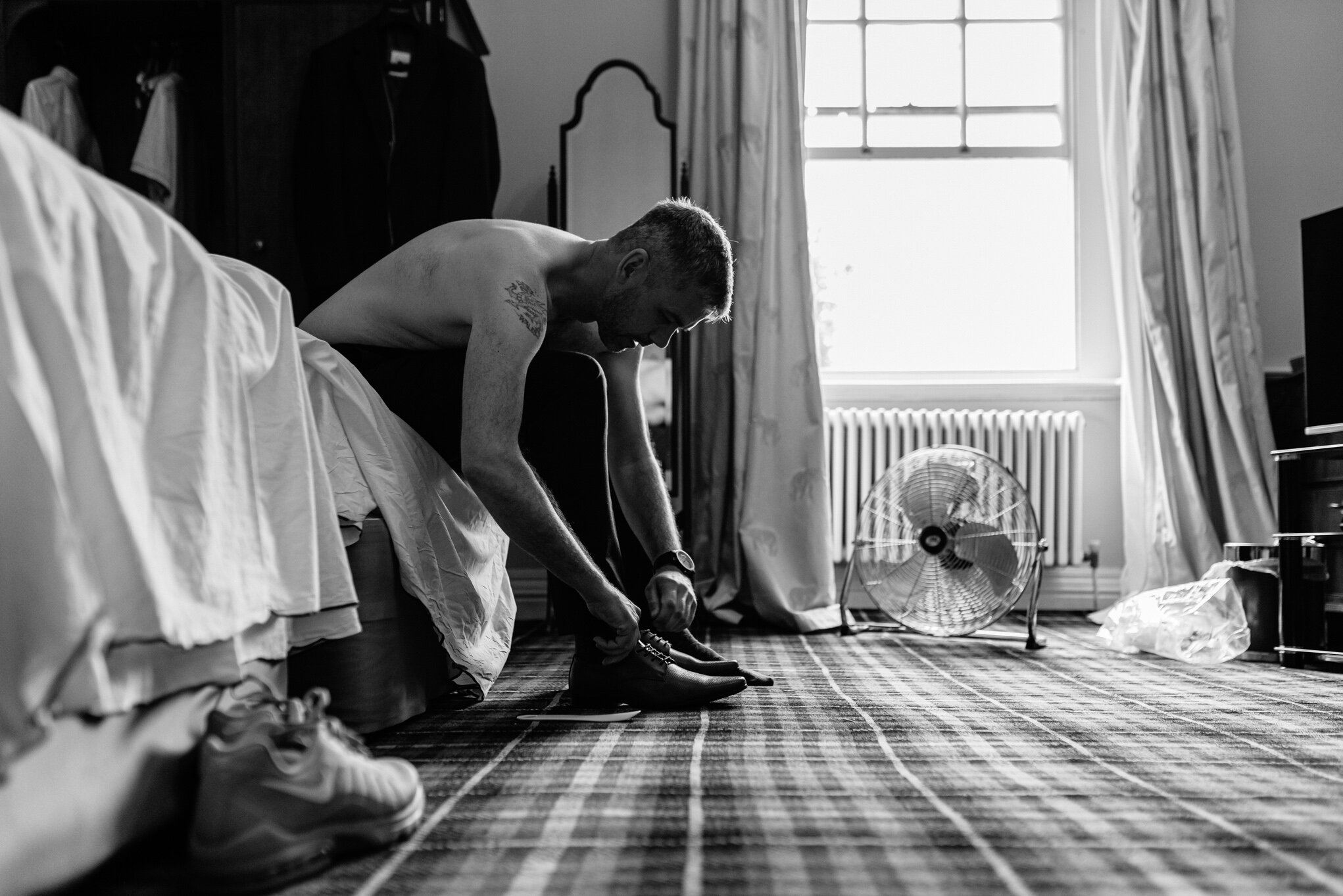 Groom tying shoe laces at Peterstone Court