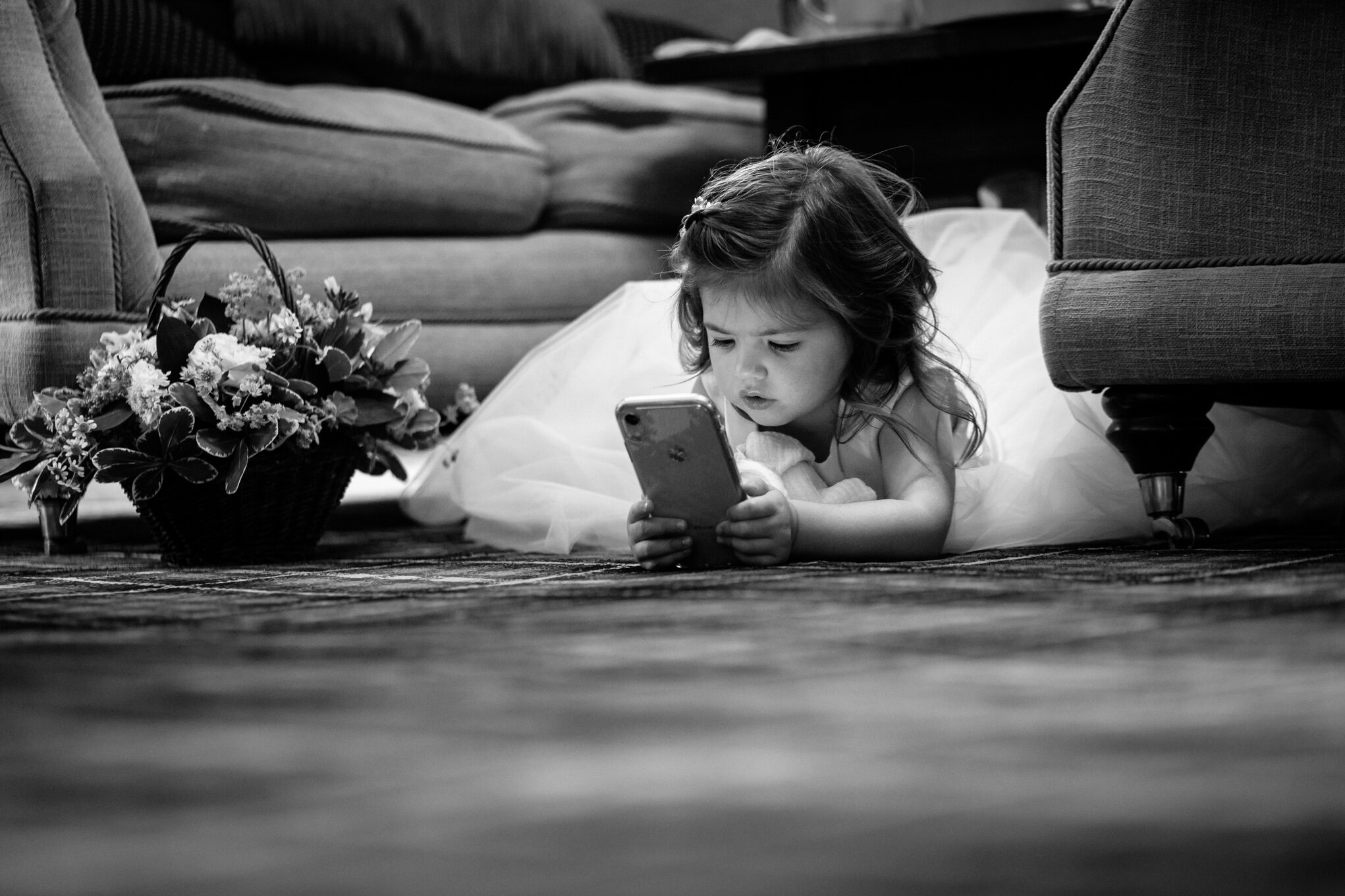 Flower girl playing with phone on floor