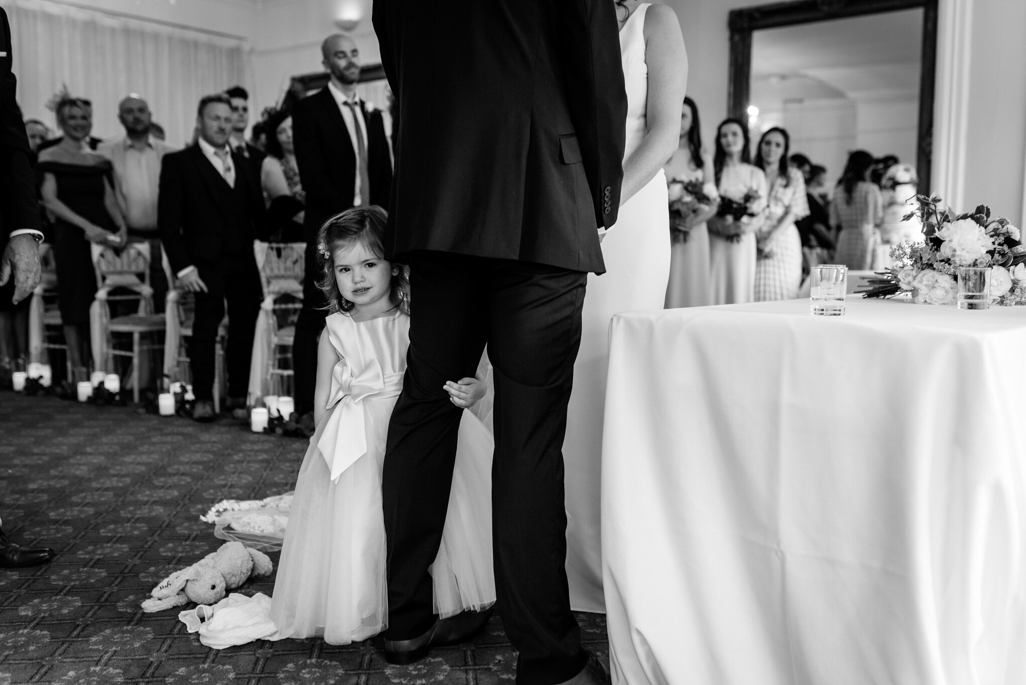 Daughter holding dads leg during wedding