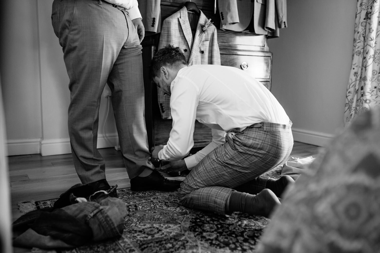 Usher having shoes done up by groom