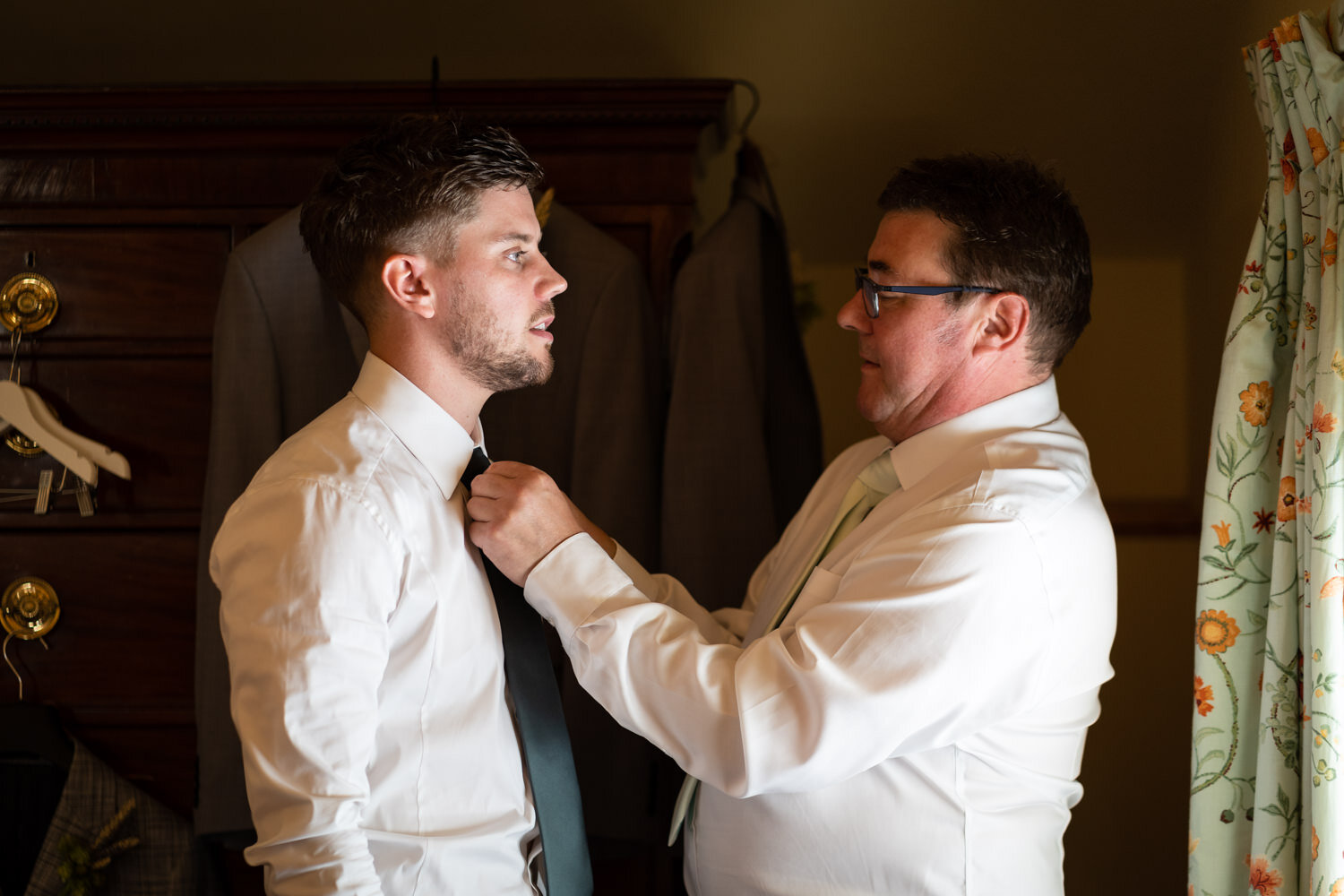 Father of groom tying grooms tie at Tall John's House