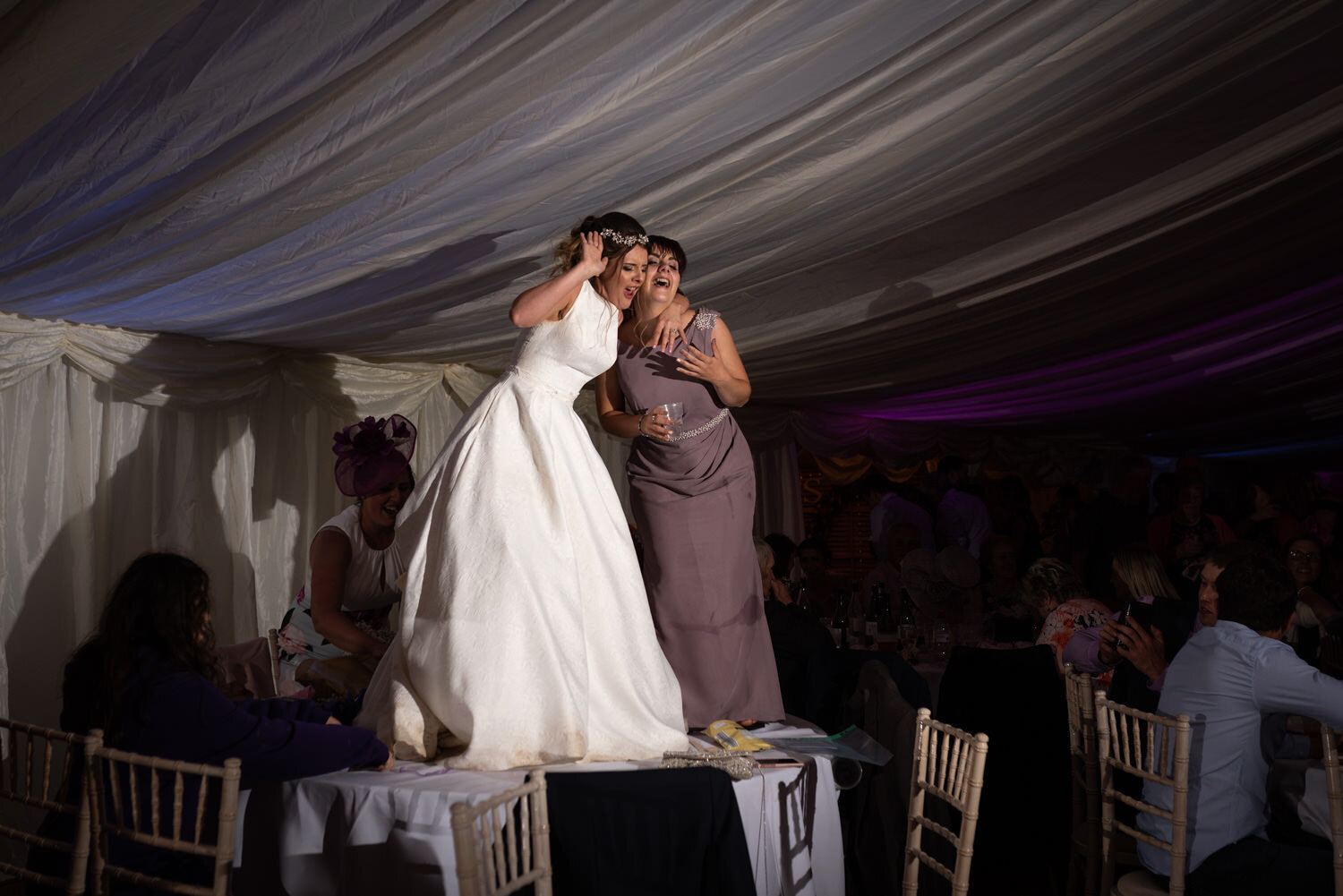 Bride dancing and singing on tables