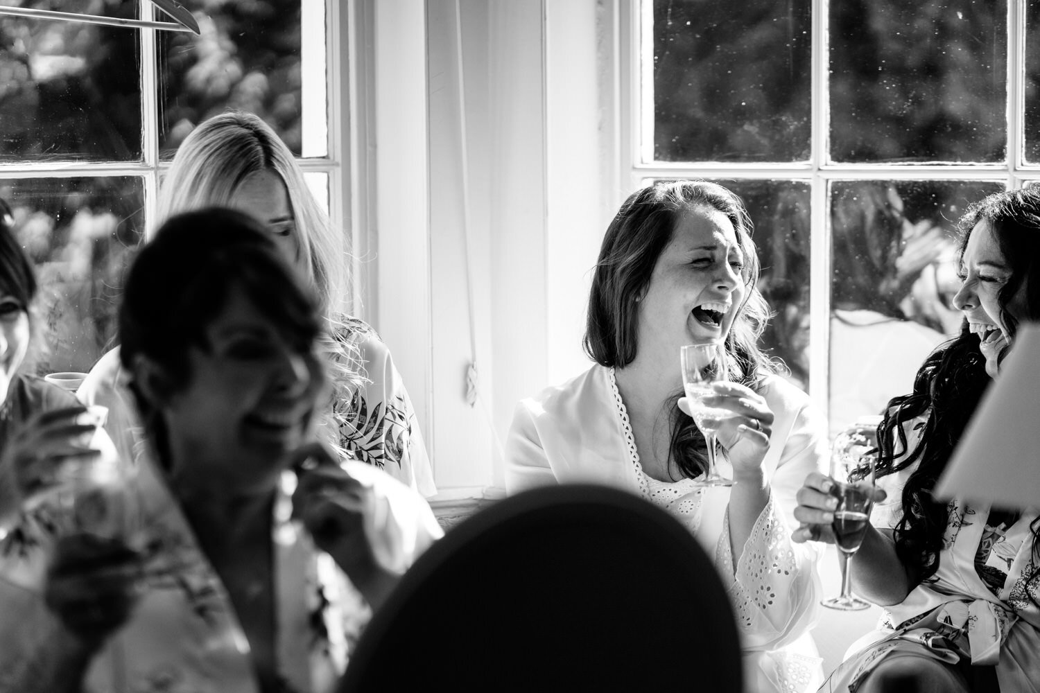 Bride laughing with bridesmaids at Tall Johns House wedding
