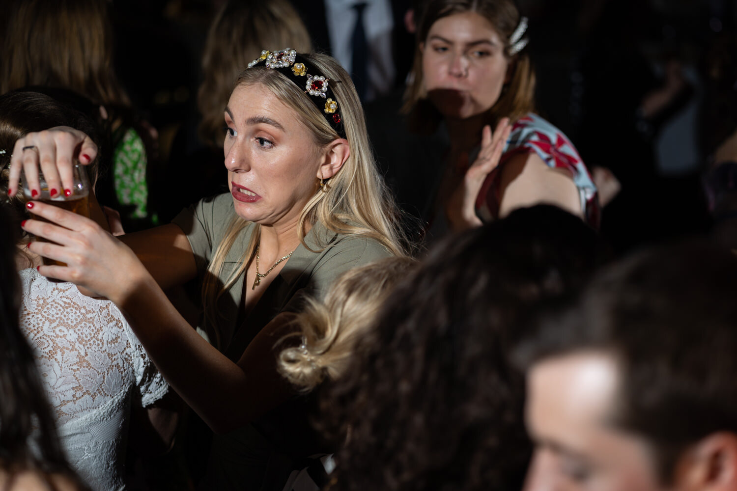 Partying wedding guest making sure drink doesn't spill