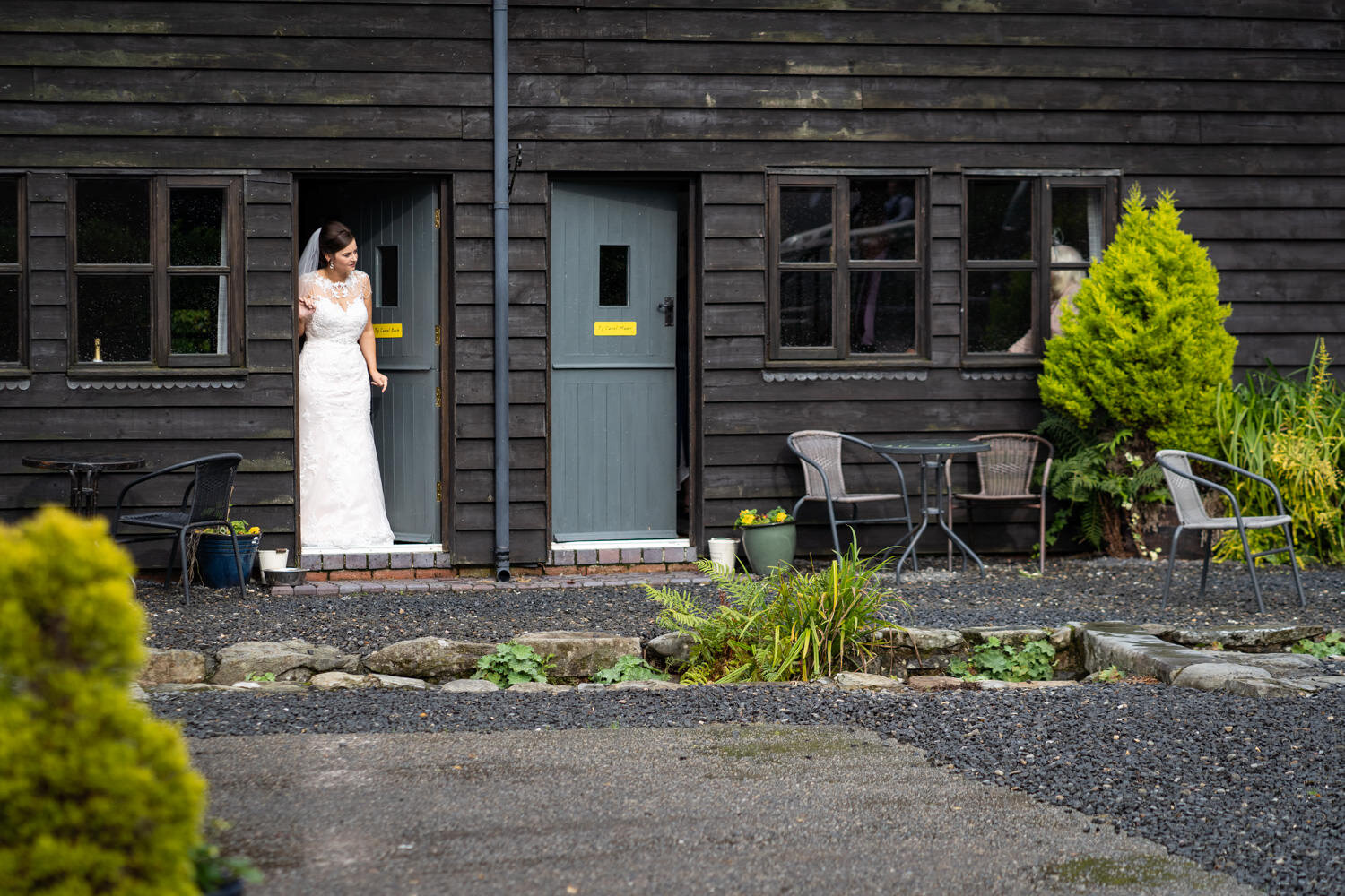 Bride in cottage doorway at Glyngynwydd Wedding Barn