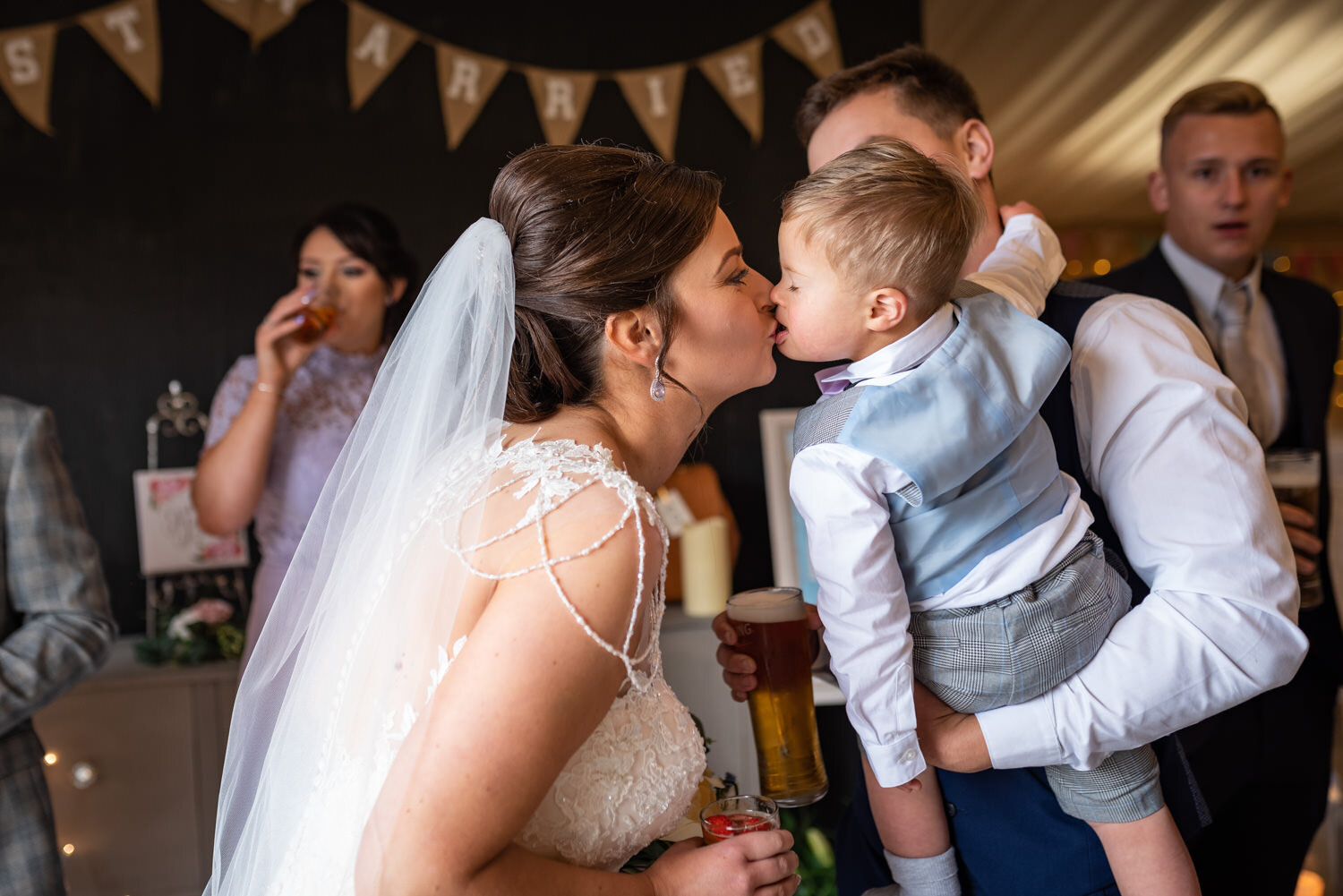 Bride kissing little boy at Powys wedding