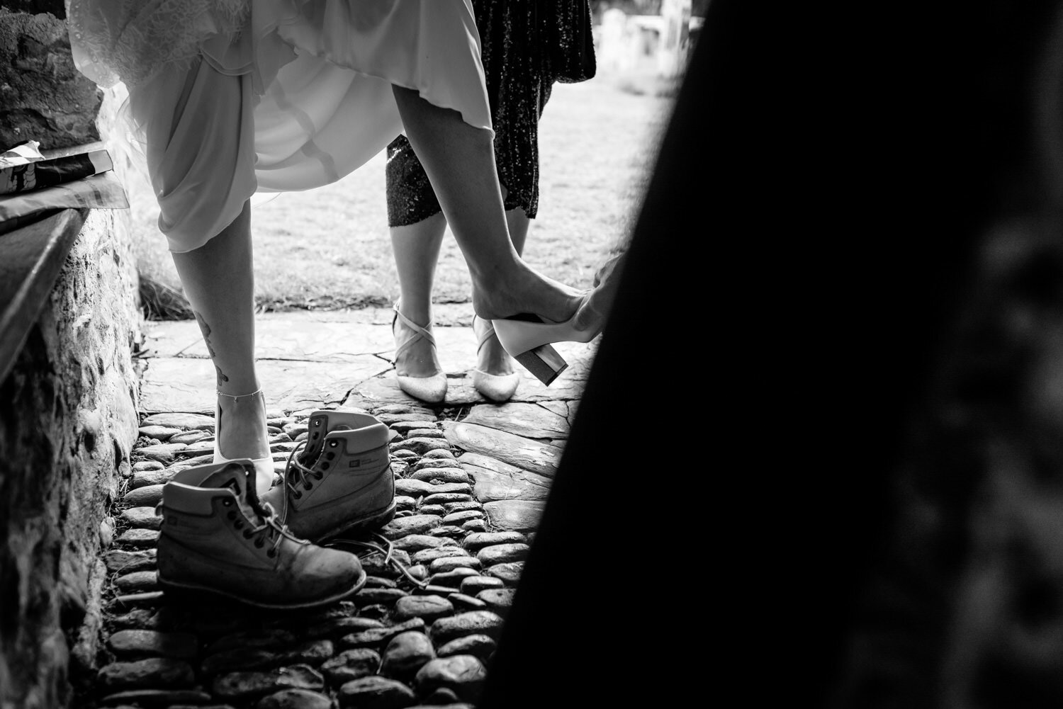 Bride changing shoes in church doorway before wedding